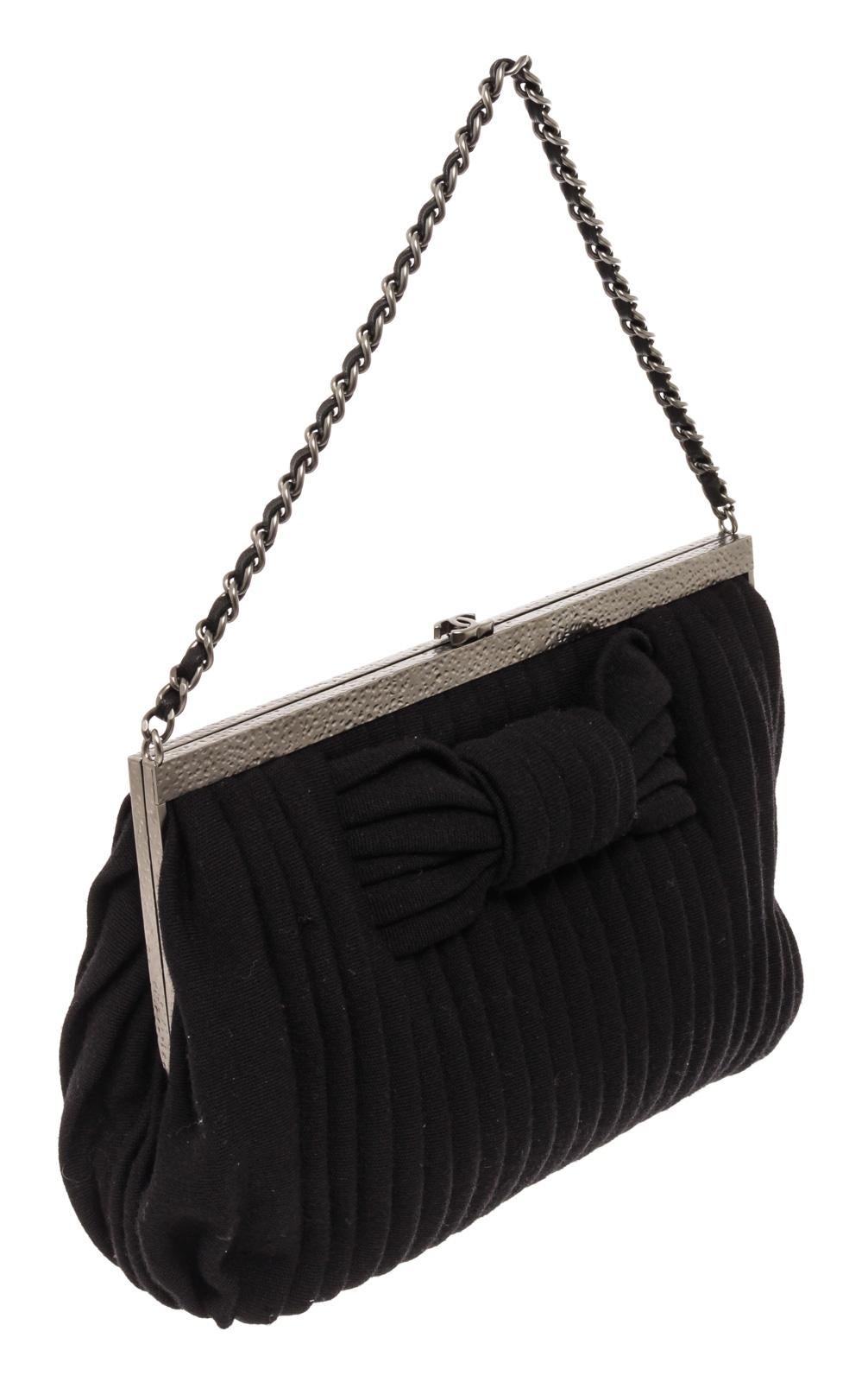 Black pleated canvas Chanel CC Party handbag with silver-tone hardware, bow motif at front body, woven canvas and chain-link top handle, kiss lock closure at top with interlocking CC logo enamel at top that will open to black canvas-lined