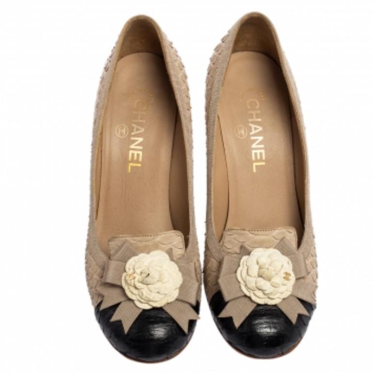 Chanel's chic-feminine aesthetics and vintage style are evident through these beautiful pumps. They are crafted using beige-black python leather, with a Camellia bow applique attached to the rounded toes. Their beauty is further elevated with 8.5 cm