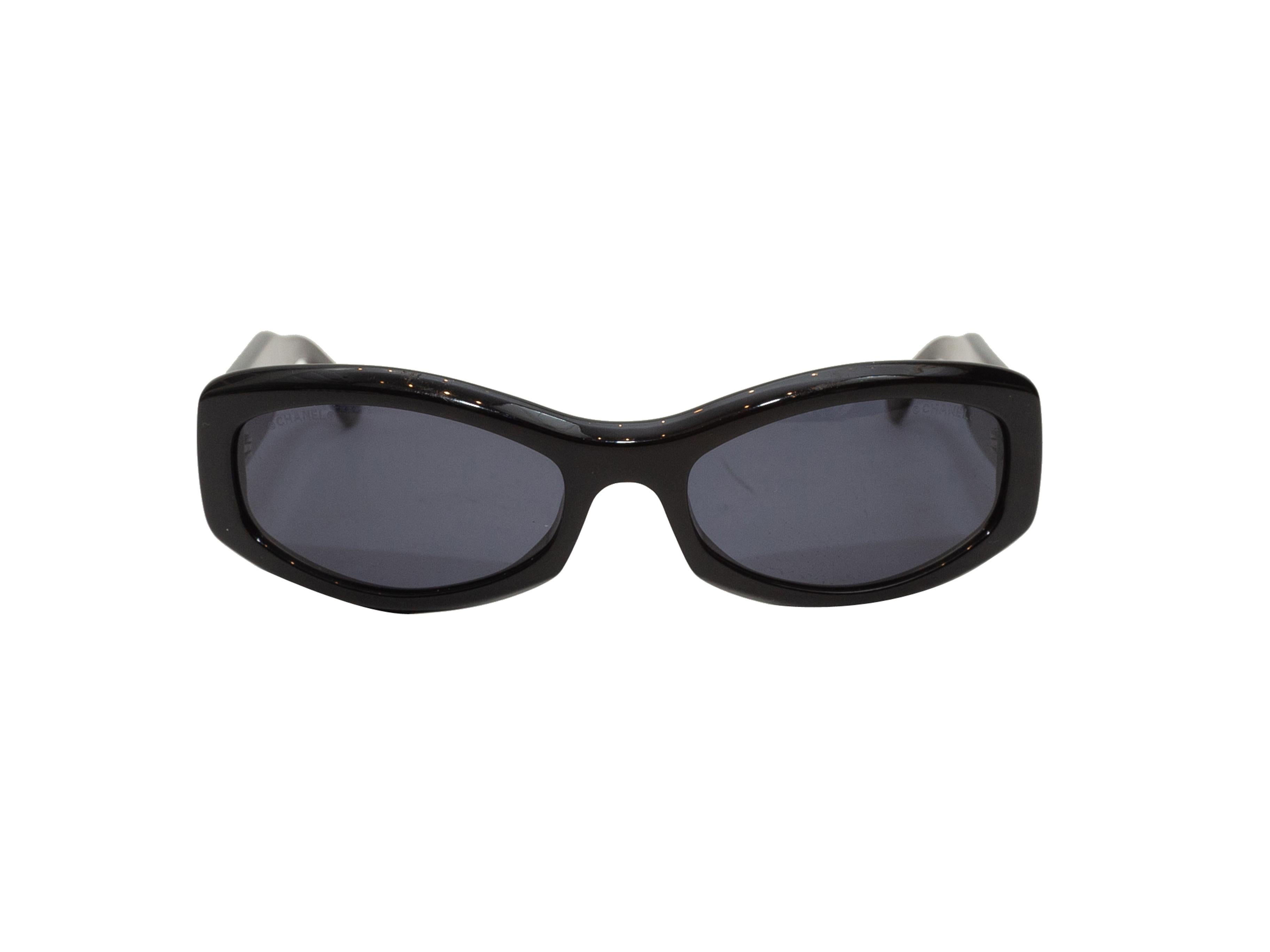 Dettagli prodotto: Occhiali da sole a braccio trapuntati in acetato nero di Chanel. Lenti colorate nere. Dettagli CC argentati sulle braccia. Altezza della montatura 1,5