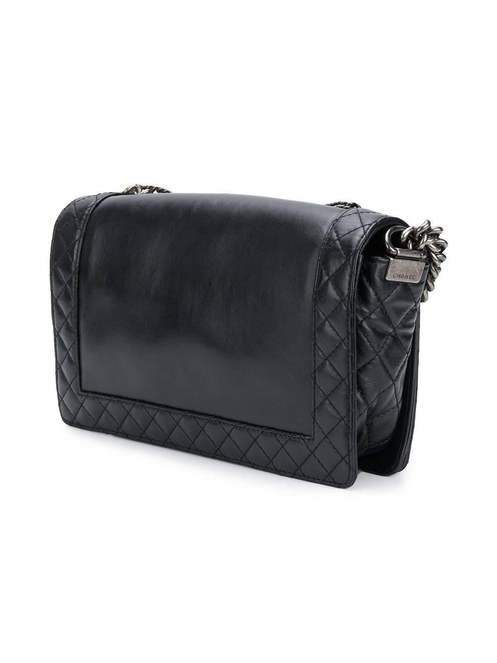 Fashioned from black lambskin, this unique Chanel Boy bag showcases the label’s iconic aesthetic and delivers a rock'n'roll inspired vibe. Adorned on the front with varied tones, shapes and thickness of chains, this striking accessory features a