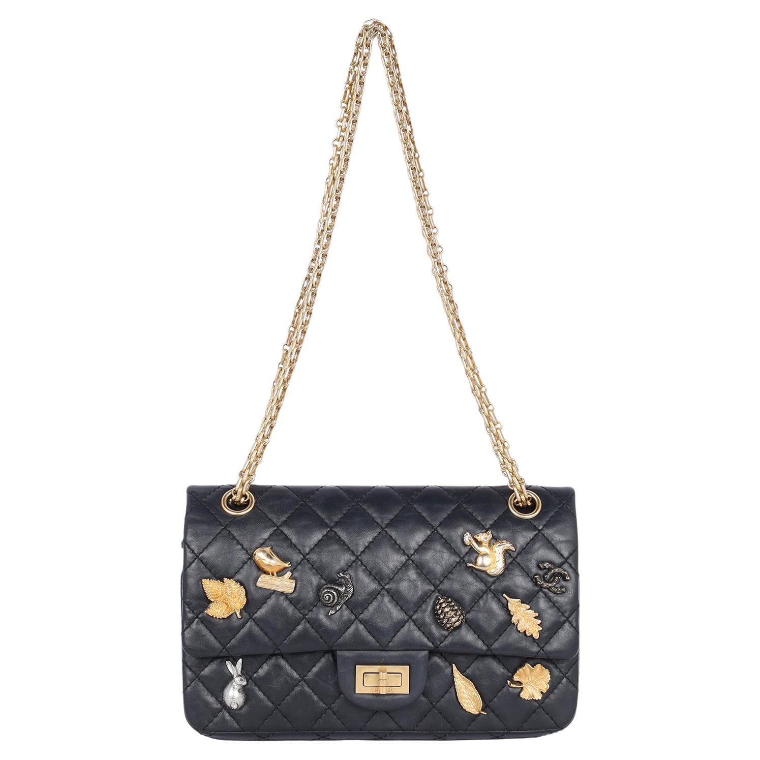 Authentic, pre-loved Chanel black double flap quilted lambskin leather 2.55 reissue lucky charm cross body bag. Features quilted leather with gold hardware, a long gold chain strap, front flap mademoiselle lock closure, charms in gold and silver.