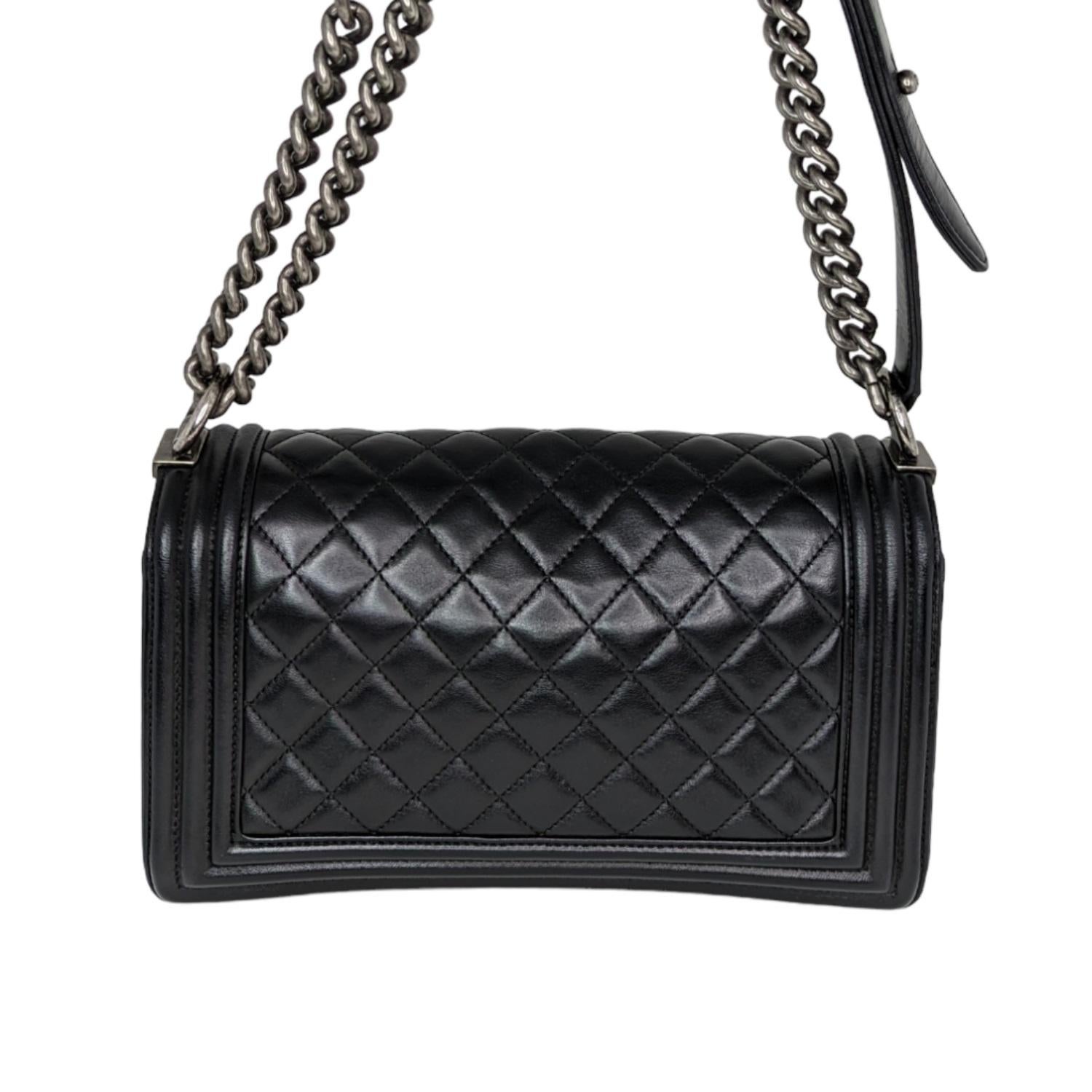 This stylish shoulder bag is crafted of luxurious diamond-quilted calfskin leather in black. The bag features a textured aged silver chain-link shoulder strap with a leather shoulder pad, and a matching boy CC push lock on the front. This opens the