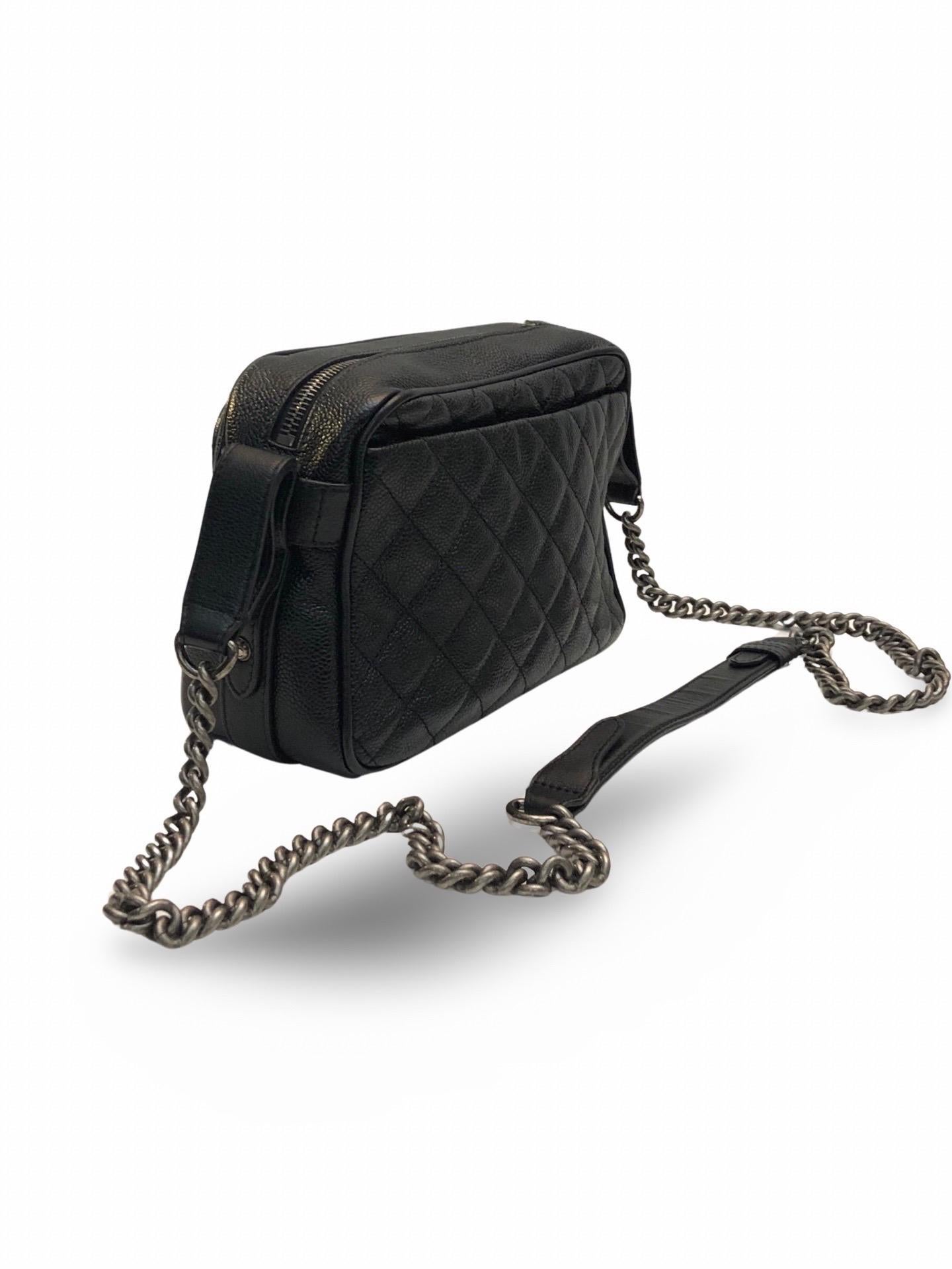 - Chanel black quilted camera bag in signature gourmette chain shoulder strap. 

- Featuring a 