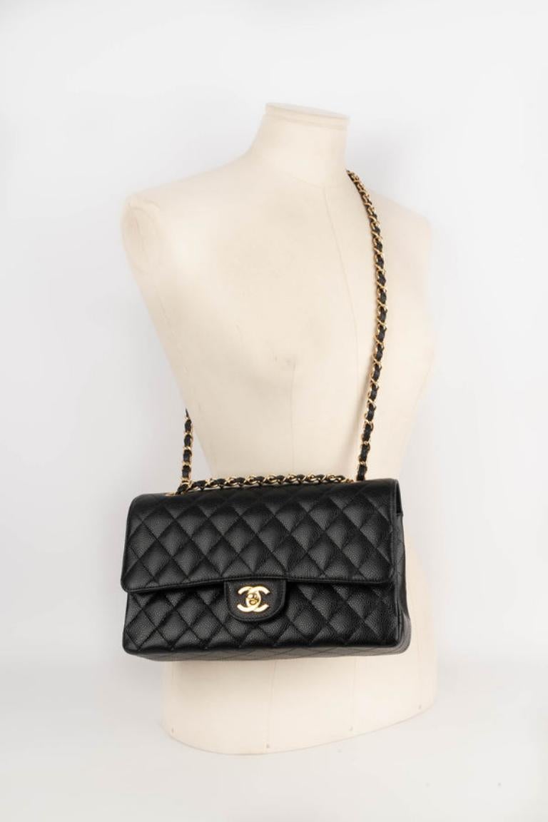 Chanel - (Fabriqué en France) Sac classique en veau grainé caviar matelassé noir avec une fermeture cc en métal doré sur un double rabat. Poignée réglable en chaîne entrelacée. Pièce avec un numéro de série et un certificat. Collectional