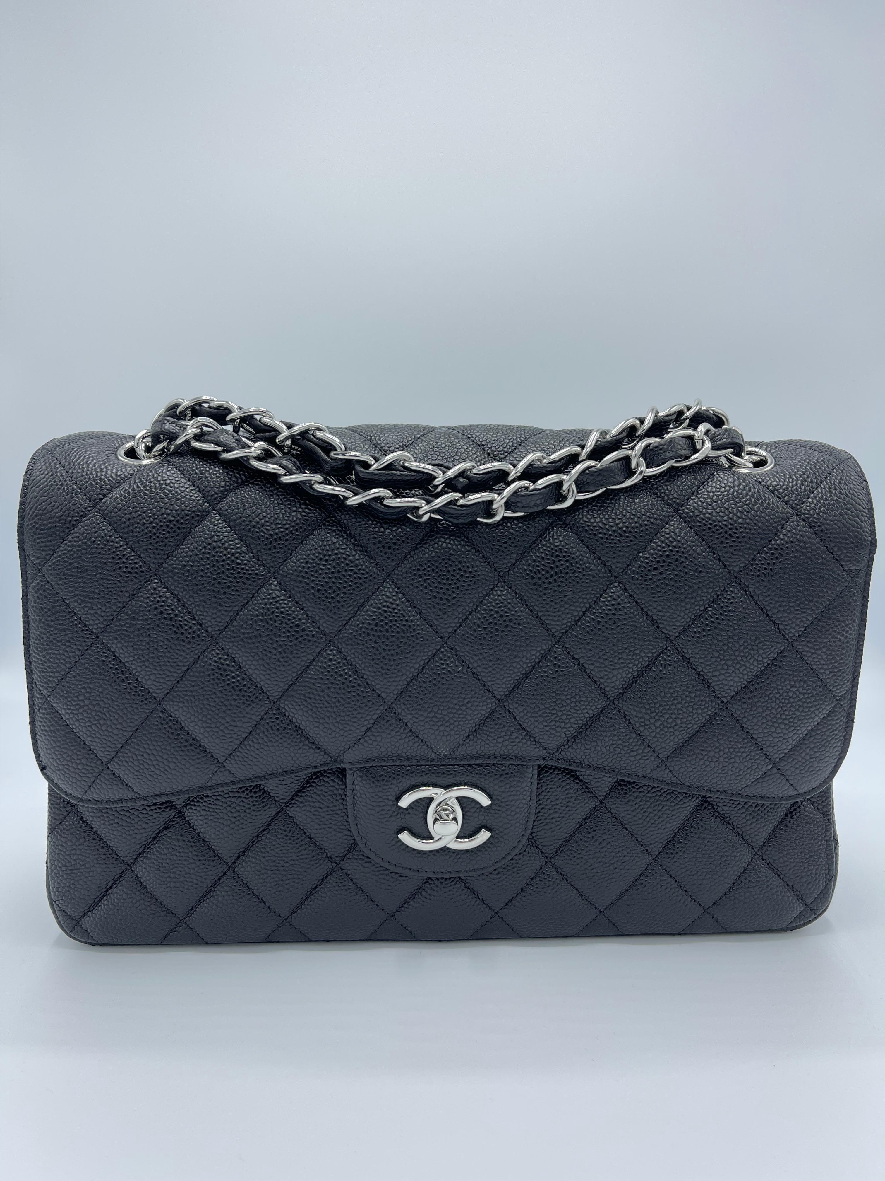 The famous Chanel Classic Double Flap new model shoulder bag is created in black grained Caviar leather and embellished with silvere turnlock and chain hardware from an early 2010 collection. 
The bag has a polished gold leather-threaded chain-link