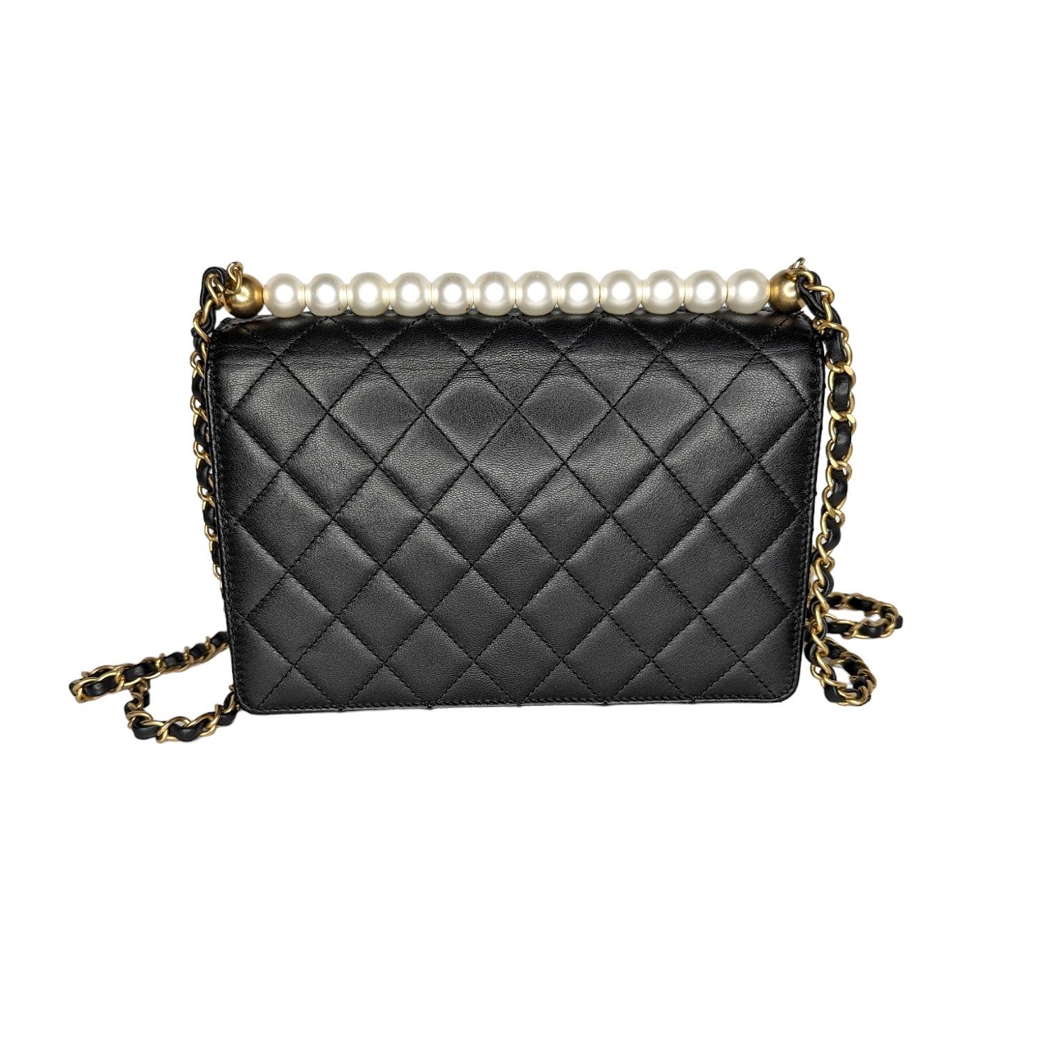 This stylish shoulder bag is crafted of diamond-quilted textured lambskin leather in black. The bag features a leather threaded matte gold chain strap, resin pearls lining the top, and a flap with a matte gold classic CC turn lock. This opens to a