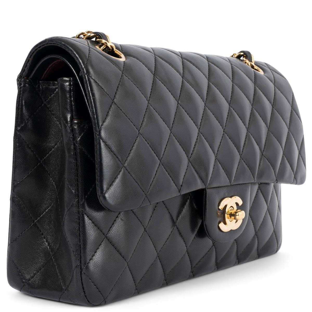 100% authentic Chanel Classic Medium Timeless Double Flap Bag in black lambskin featuring gold-tone hardware. Open pocket on the back. Closes with classic CC-turn-lock on the front. Zipper pocket inside the flap. Outside pocket on the front under