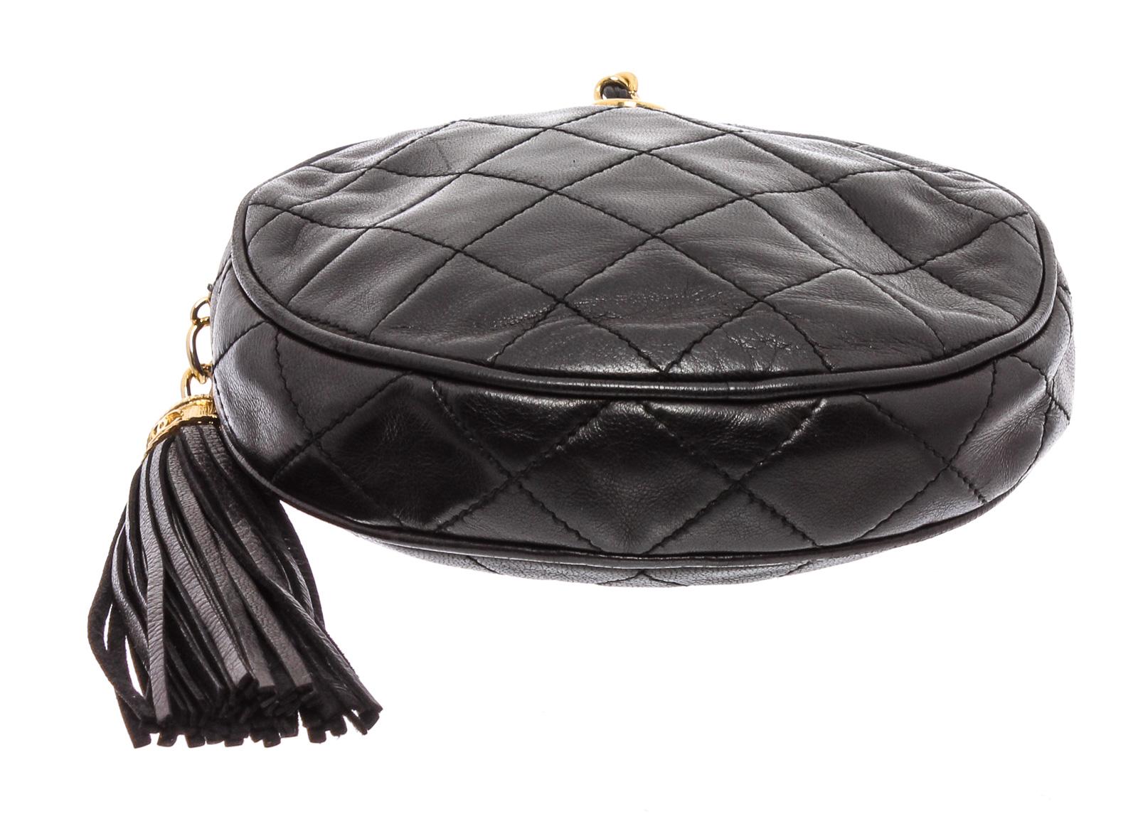 Black quilted lambskin leather Chanel Round clutch bag with fringe tassel zippered closure, gold-tone hardware and chain wrapped wristlet.

21864MSC MLA
