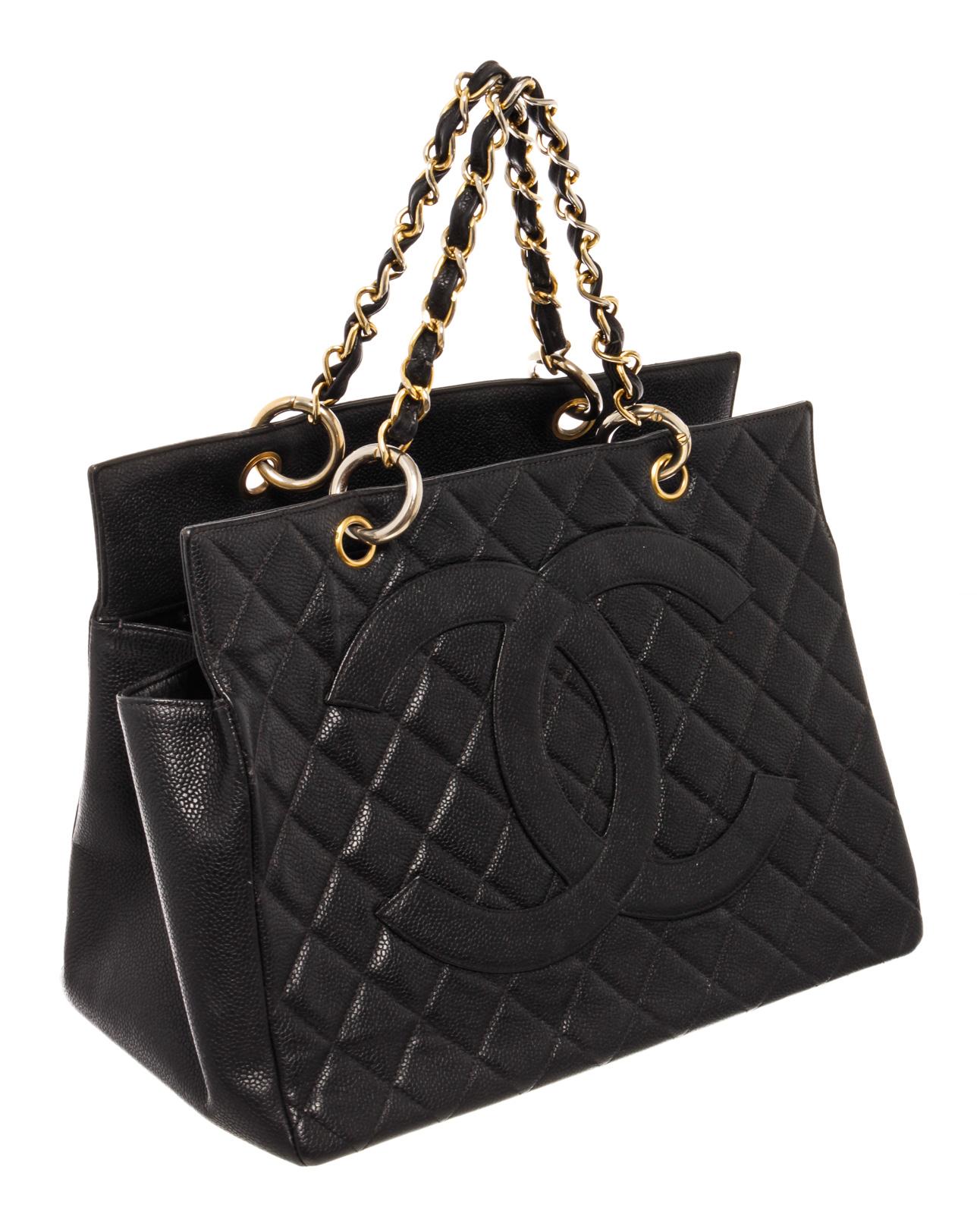 Black quilted Lambskin leather Chanel Grand Shopping Tote with gold-tone hardware, dual chain-link, single patch pocket at back, quilted CC logo at front, tonal grosgrain lining and multiple pockets inside; one with zip closure and open top.

