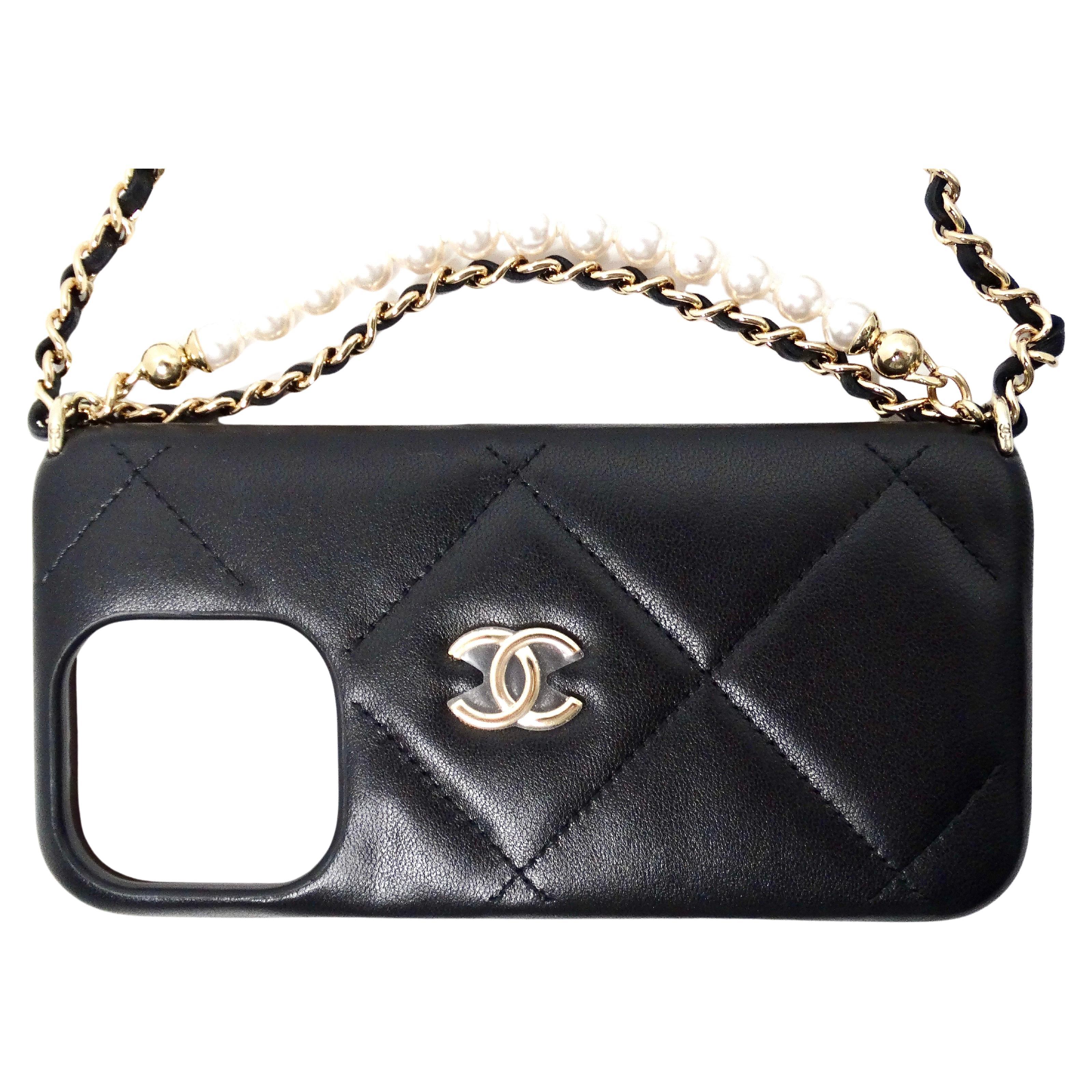 L'étui Chanel Black Quilted Lambskin Pearl Crush iPhone 15 Pro Case With Chain pour 2024 incarne le luxe et la sophistication, mêlant mode et fonctionnalité. Confectionné en cuir d'agneau matelassé noir, il présente un étonnant motif perlé écrasé