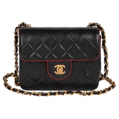CHANEL Schwarze quadratische Mini-Klappentasche aus gestepptem Lammfell mit roter Verzierung