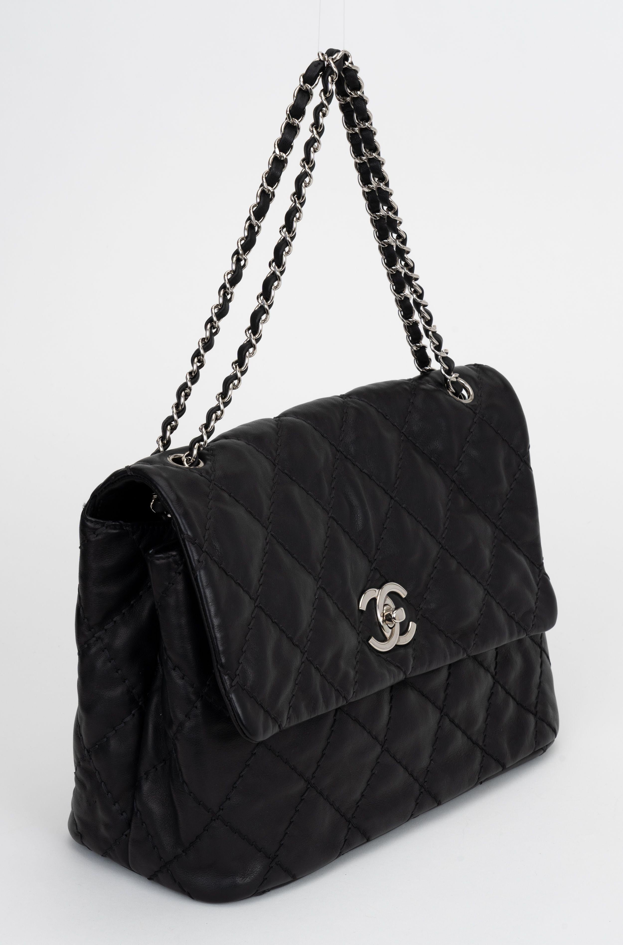 Bolso negro acolchado Chanel en perfecto estado con herrajes plateados. Compartimento central con cremallera y 2 espacios laterales, bolsillo trasero. Caída del hombro 9