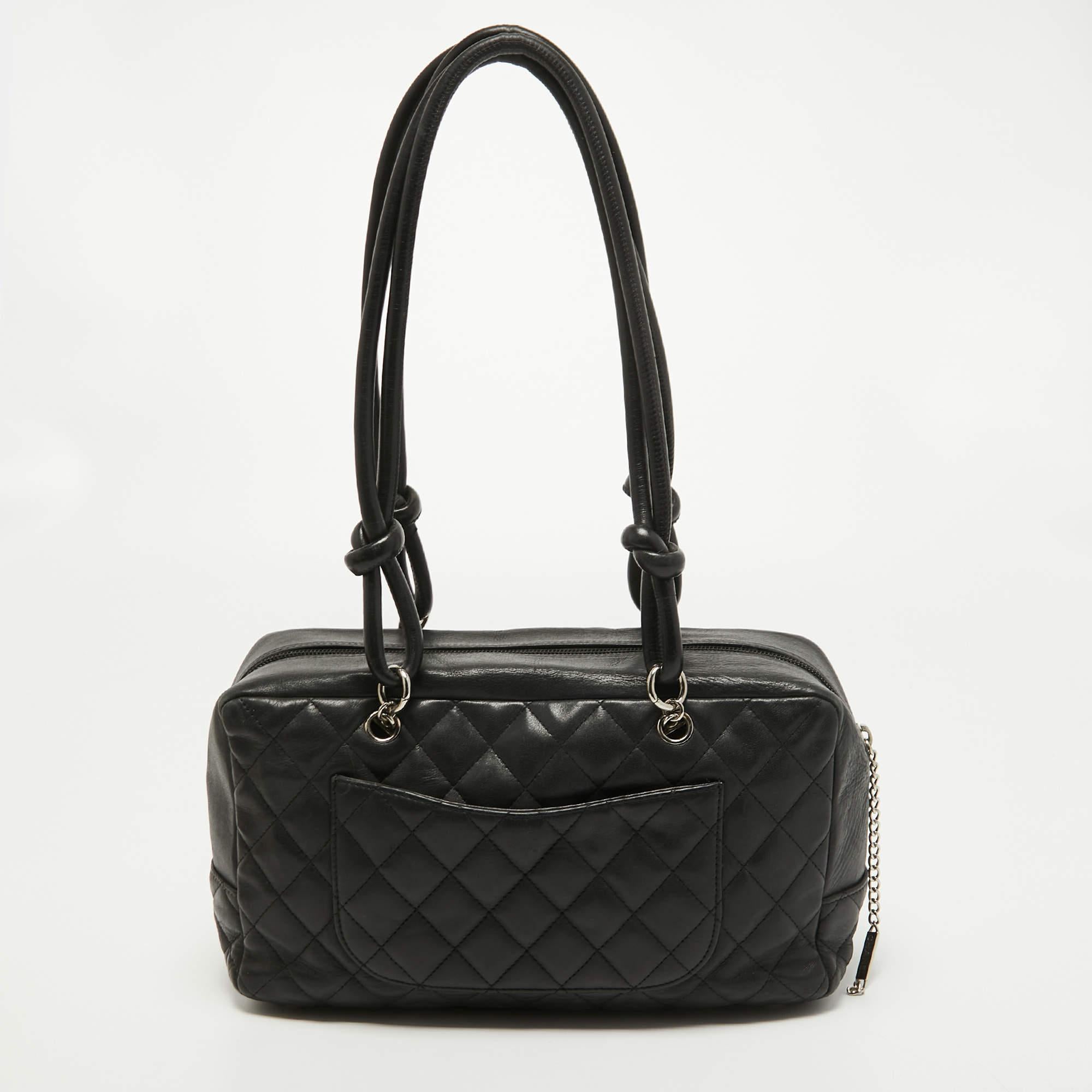 Radiate with elegance when you swing this Bowler bag from Chanel. Beautifully crafted from quilted leather in black and designed with the CC logo on the side, this bag is a beauty. A zip closure secures a spacious interior, and the bag is held by