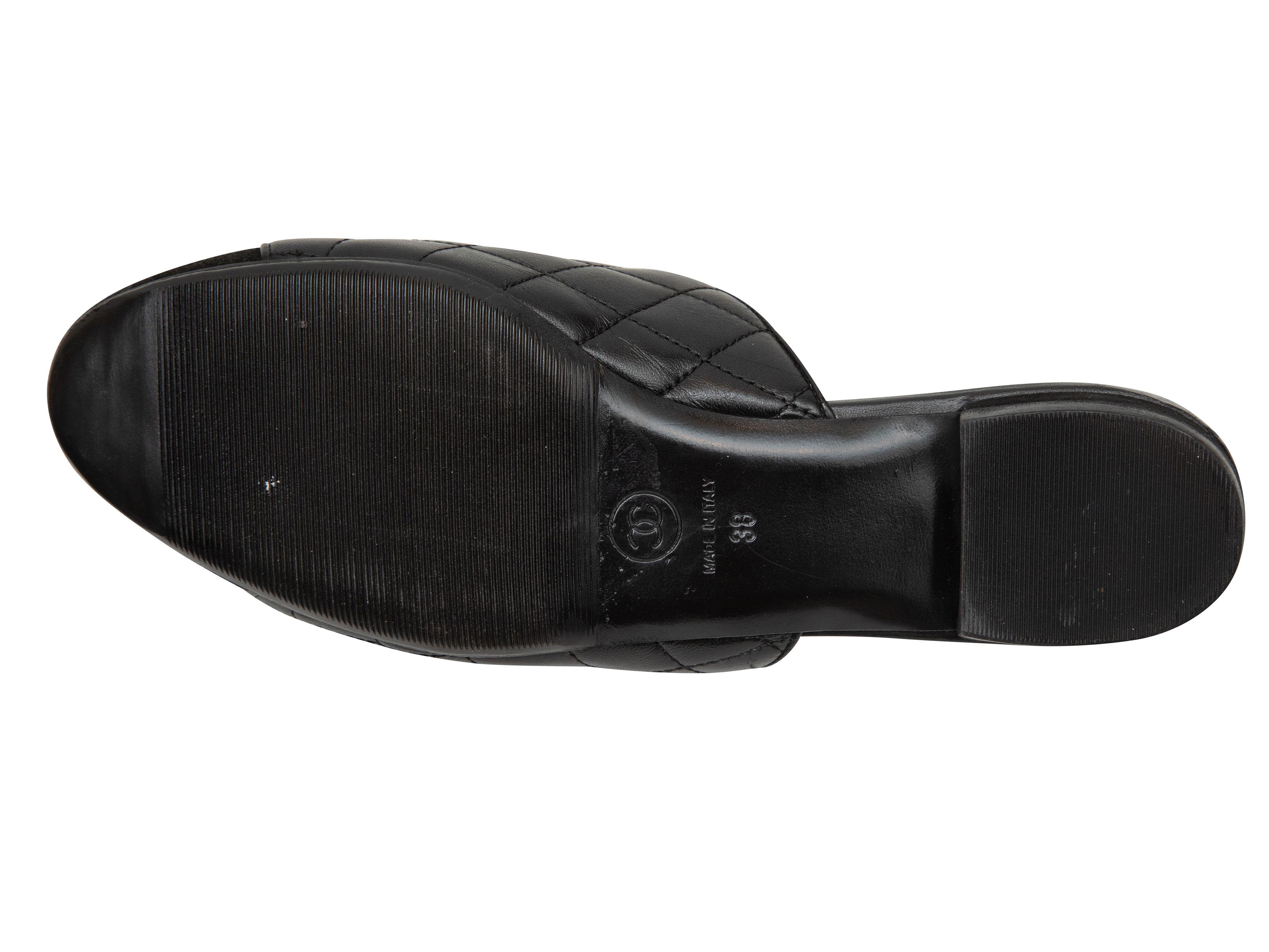 Product Details: Black quilted leather and textile cap-toe flat mules by Chanel. Logo embroidery at toes. 1