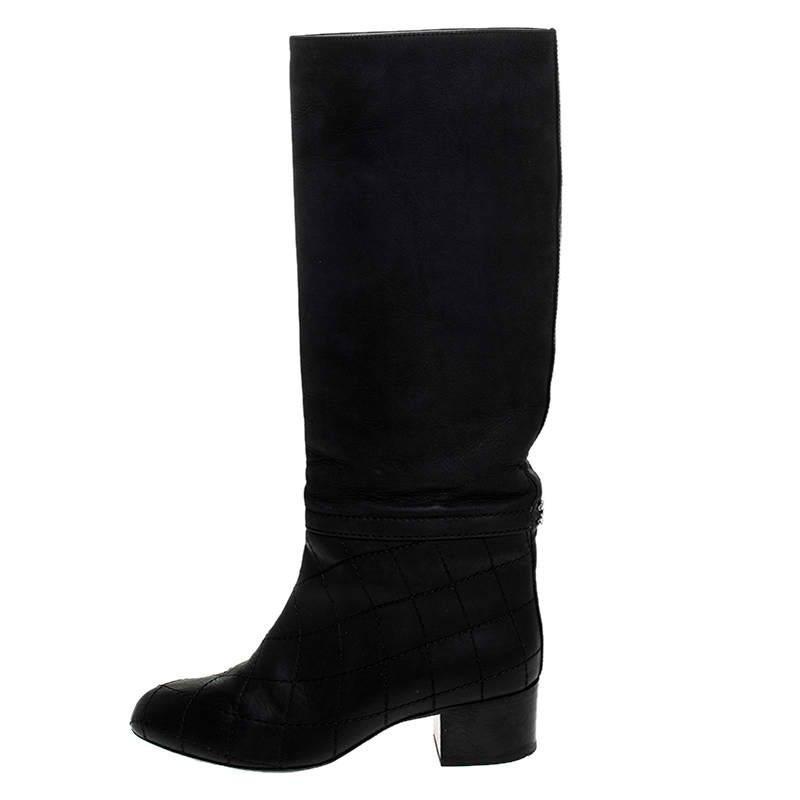 These stunning boots by Chanel exude sophistication and deliver comfort. Crafted in Italy, they are made from quality leather and come in a classic shade of black. The exterior of these knee-length boots is made interesting with the bottom half