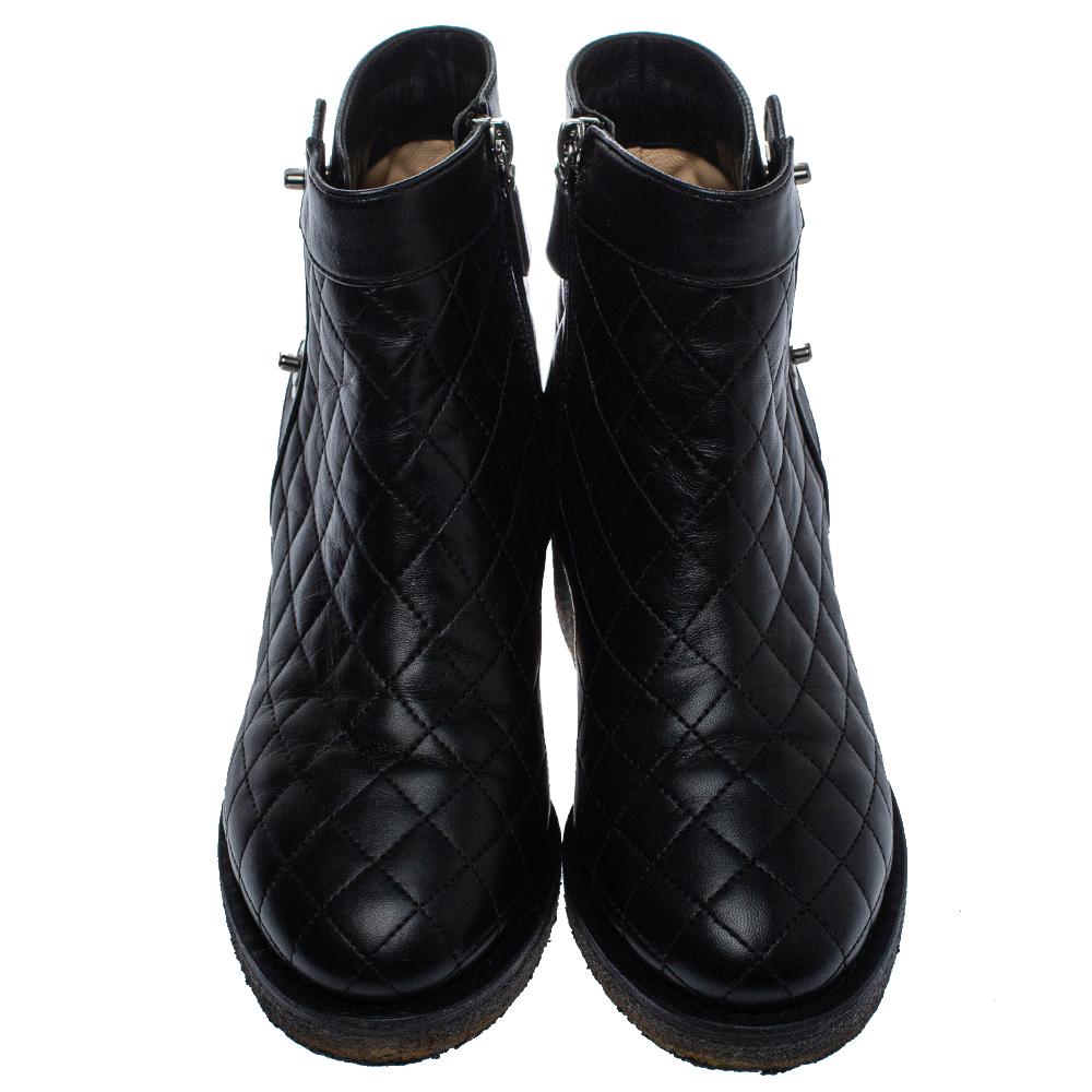 Add a high-end update with these ankle boots from Chanel. Crafted from quilted leather, these black designer ankle boots feature round toes, CC turn-lock detailing, and zip closure. They are elevated on short block heels and luxuriously lined with