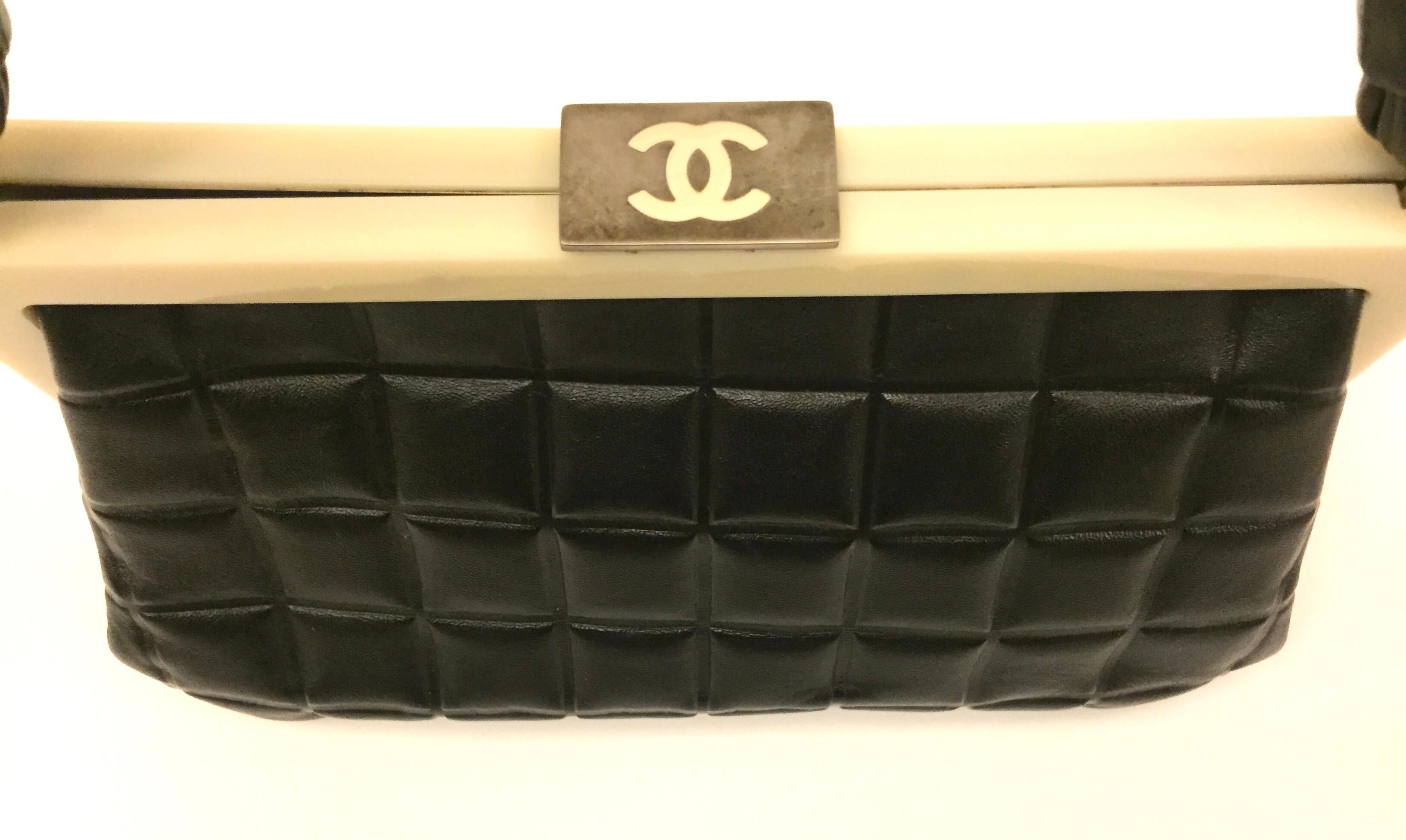- Chanel black quilted leather chocolate bar handle bag from year 2002 to 2003 collection. 

- Silver- tone hardware, single flat top handle, single pocket at interior and push-lock closure at top.

- Measurements: 23cm x 13cm x 10cm. Drop: 16cm. 

