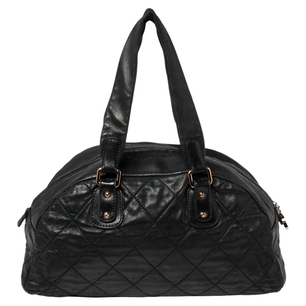 This luxurious Cloudy Bundle bowler bag by Chanel is a note-worthy design. Crafted with quilted leather, it features dual top handles and rose gold-tone hardware. This bag has a top zip-up closure that reveals a fabric-lined interior sized to assist