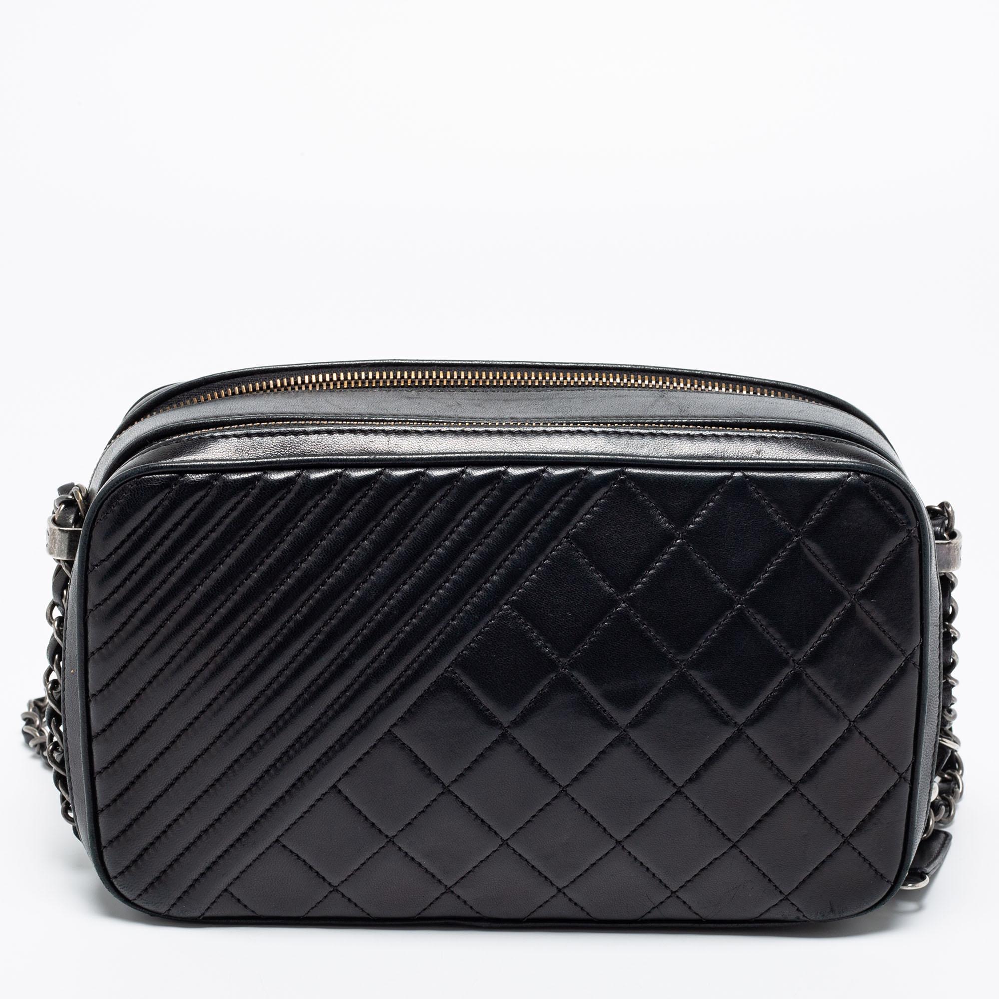 This Coco Boy Camera case bag from Chanel exudes the right amount of class and elegance. Crafted from black quilted leather, this bag is adorned with a sturdy chain strap and silver-toned hardware. It accommodates a fabric-lined interior. Make this