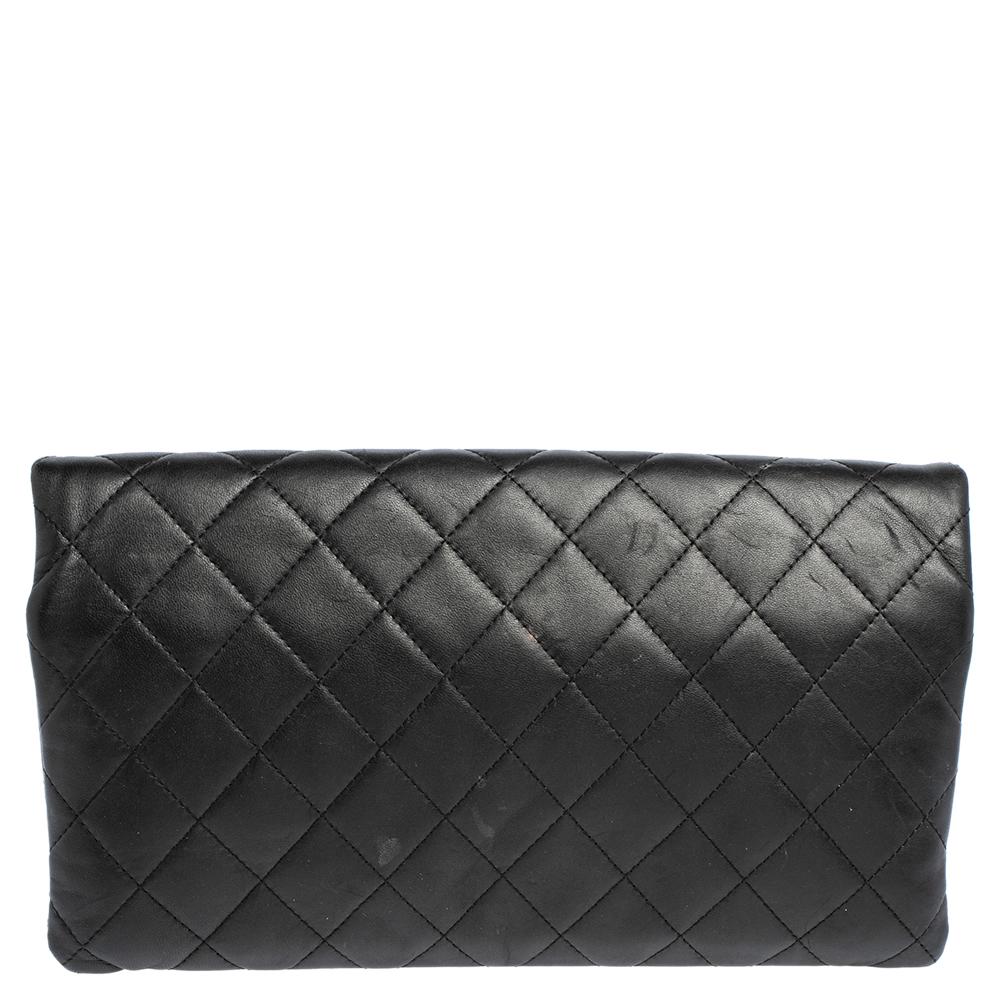 This Chanel clutch is expertly crafted in a simple yet striking silhouette. It is made from black signature quilted leather and the top portion folds over to create two separate zipper pouches. The flap is furnished with a silver-tone interlocking