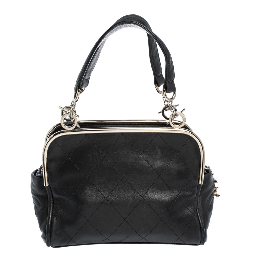 Give your look sophistication with this black-hued bag by Chanel. This elegantly shaped handbag is crafted from quilted leather with a lovely finish. The exterior is accented with silver-tone metal frame and dual handles. Lined with nylon, the bag