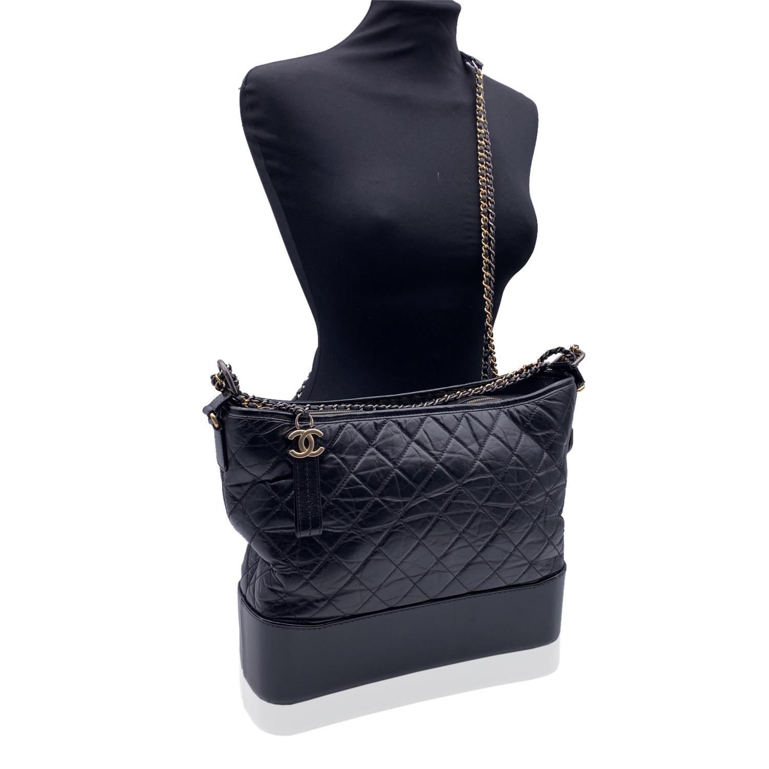 Chanel Gabrielle Large Hobo Bag crafted in black quilted leather. Period/Era: 2017. The bag is inspired by vintage binocular cases that men wear at the racecourse. Unisex model. It is crafted in black leather and it feature upper zipper closure,