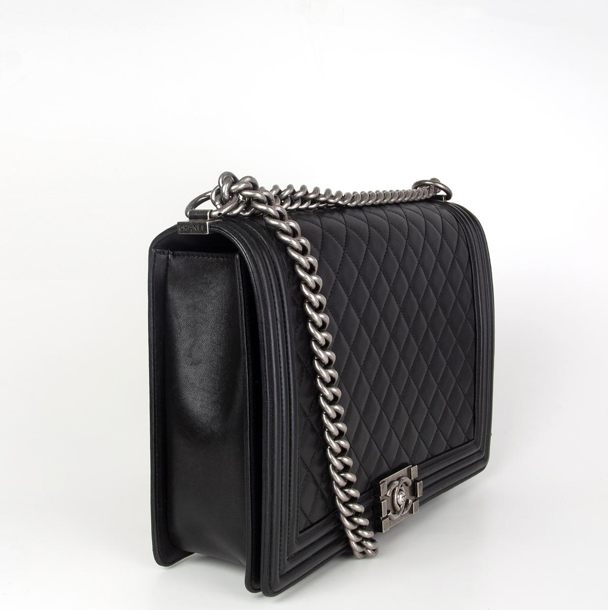 Chanel 'Boy' large shoulder bag in black quilted calfskin leather featuring antique silver-tone hardware. This is the original size that's no longer available. Opens with a CC push-lock and is lined in grey gros grain fabric with two open pockets
