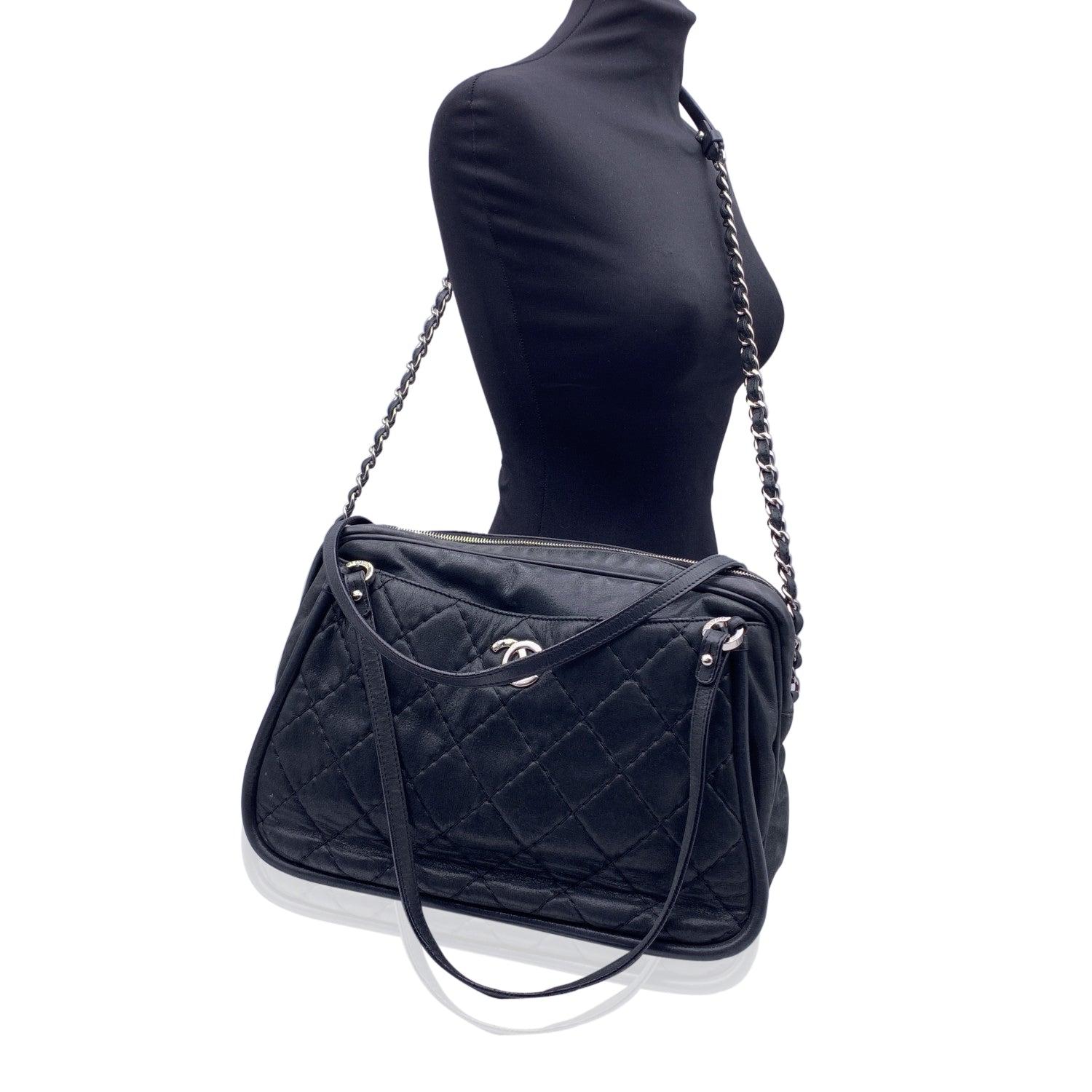 Introducing the Chanel Relax CC Tote Camera Shoulder Bag, a sophisticated and versatile piece that exudes the timeless elegance of Chanel. Crafted in luxurious black quilted shimmery leather, this bag has a subtle sheen that catches the light