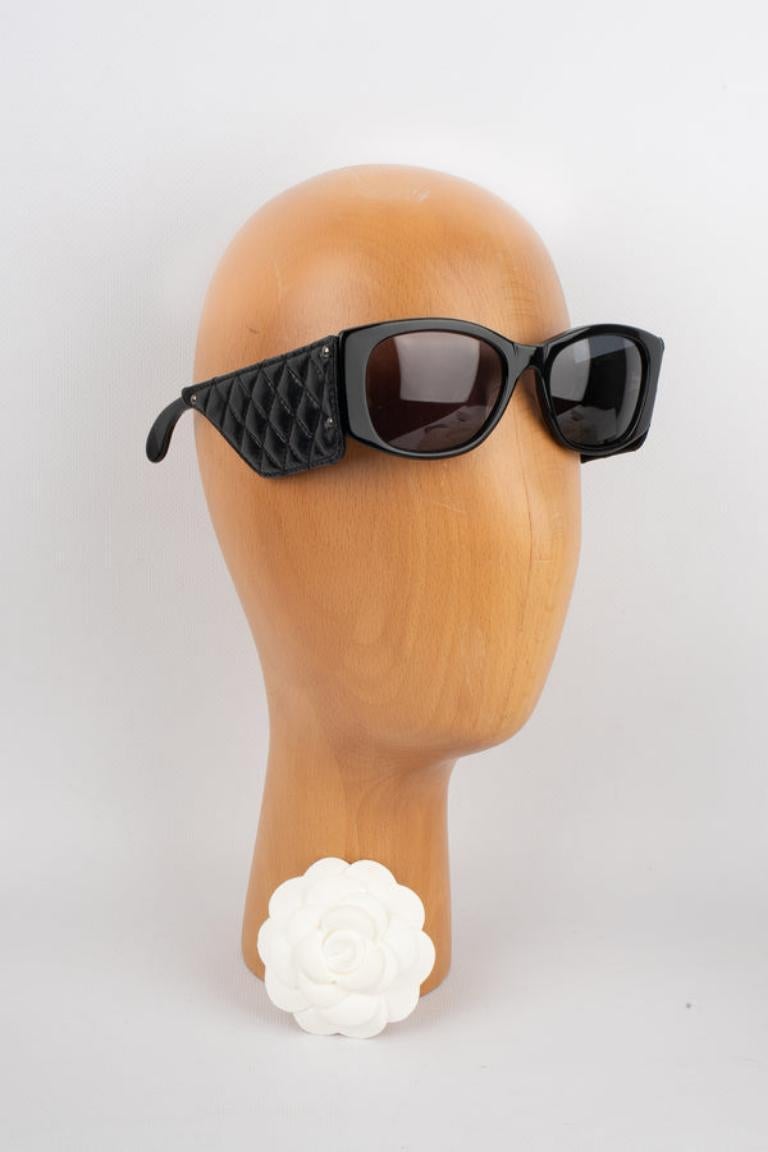 Chanel - (Made in France) Sunglasses ornamented with black quilted leather on the arms. 1988 Collection.

Additional information:
Condition: Good condition
Dimensions: Length: 14 cm
Period: 20th Century

Seller Reference: ACC153