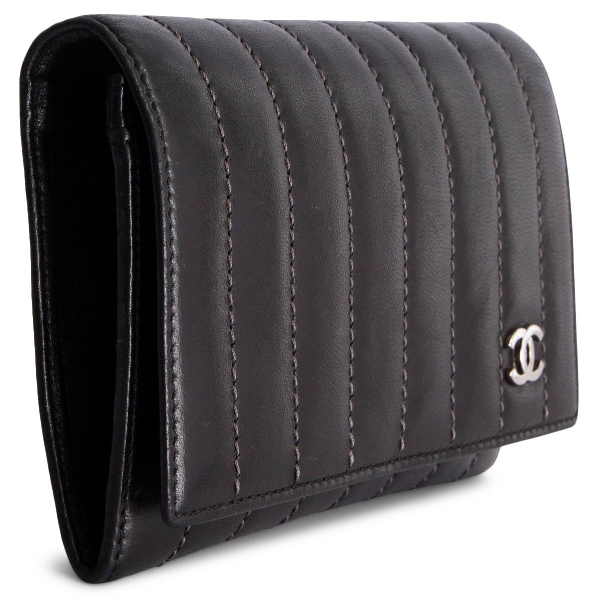100% authentische Chanel Brieftasche mit genähten Streifen in grau. Sie wird mit einem Druckknopf geöffnet und ist mit schwarzem Lammfell und Logo-Nylon gefüttert. Das Design ist in zwei Fächer mit 3 Kreditkartenfächern und einem Münzfach mit