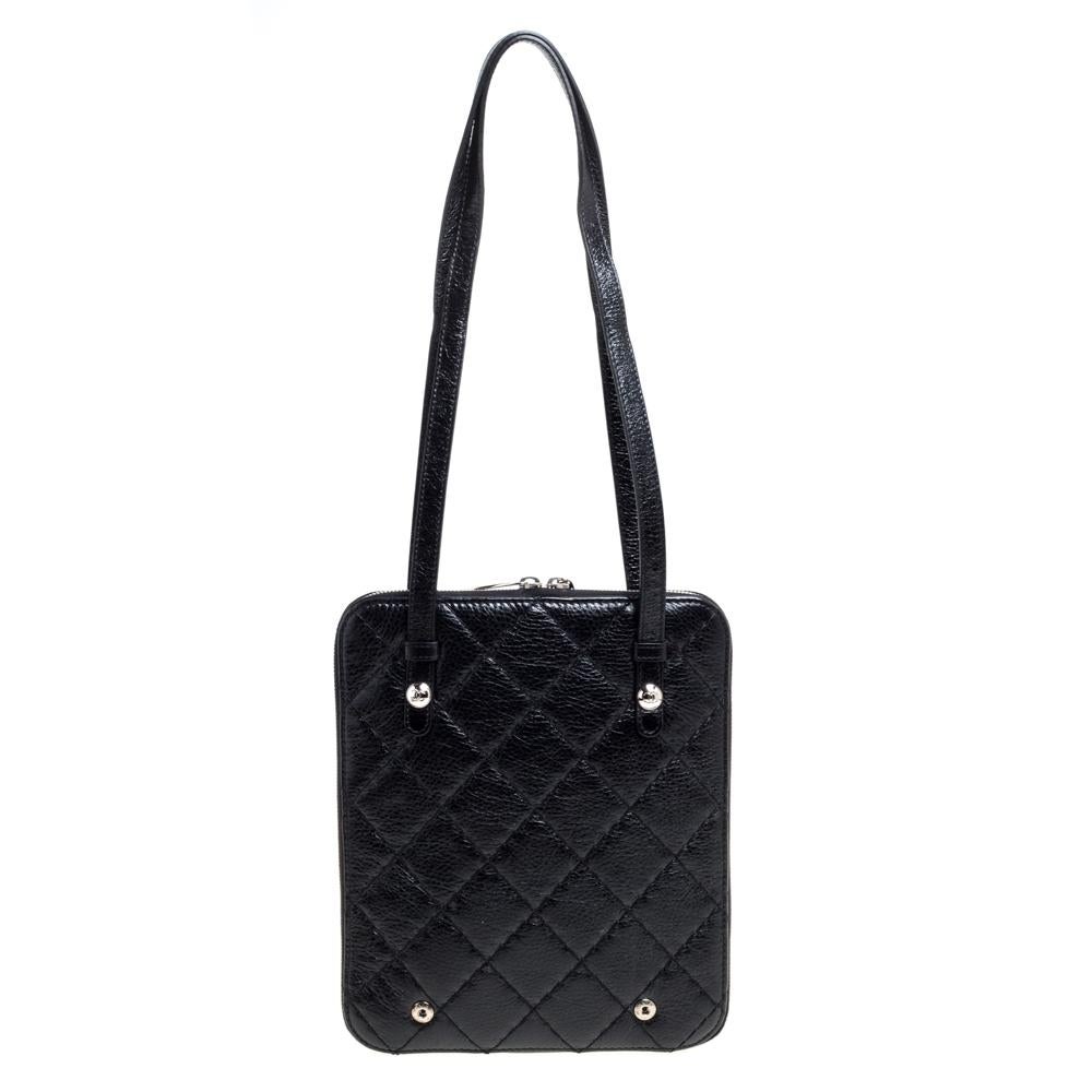 This Chanel bag is a buy that is worth every bit of your splurge. Exquisitely crafted from black quilted leather, it features silver-tone stud detailing and a phone pocket on the front. The zip around fastening opens to a satin-lined interior