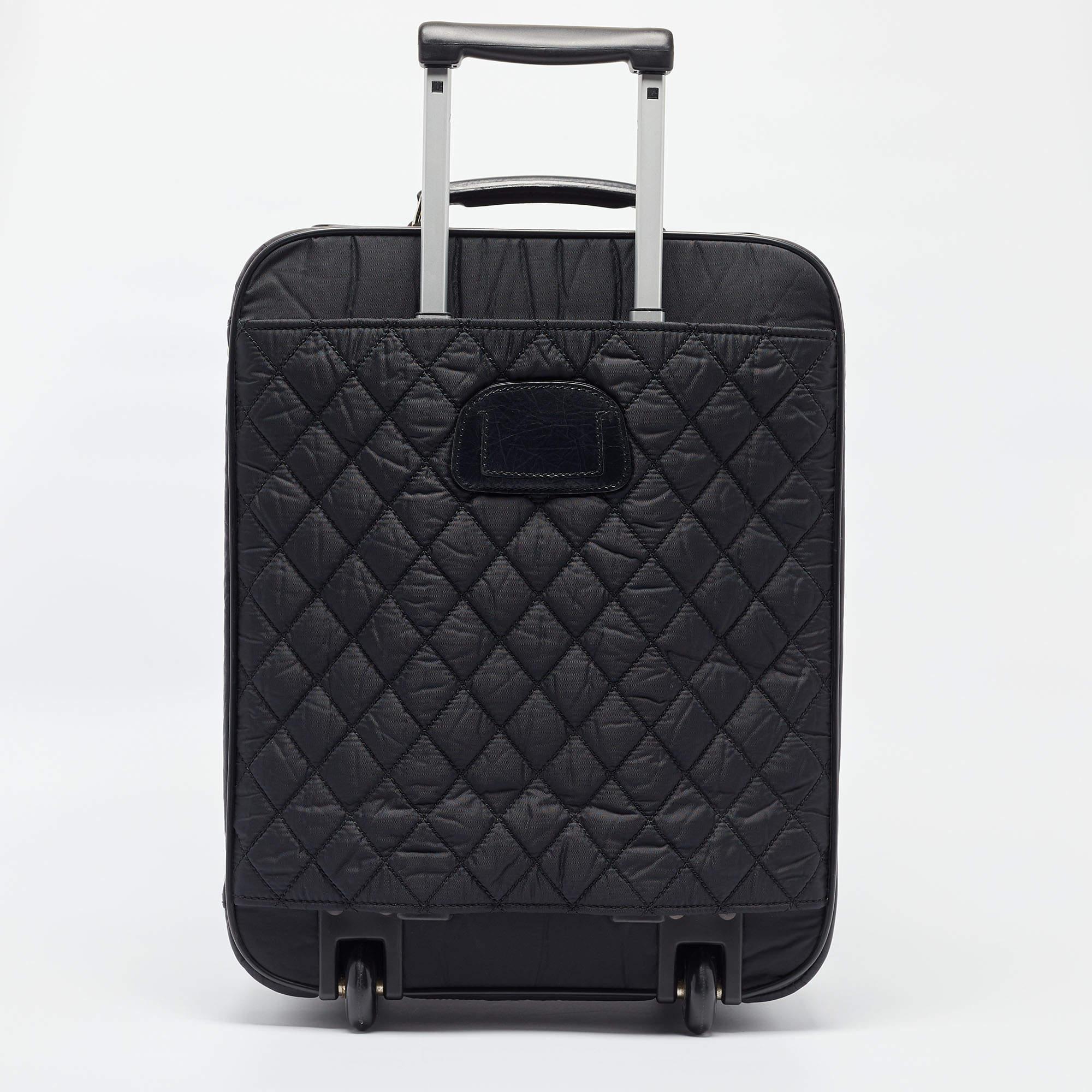 Voici les bagages Chanel CC, une fusion de luxe et de praticité. Confectionné en nylon matelassé résistant, il dégage un charme intemporel. Le logo CC emblématique ajoute une touche d'élégance. Équipé de deux roues à roulement souple, il promet des