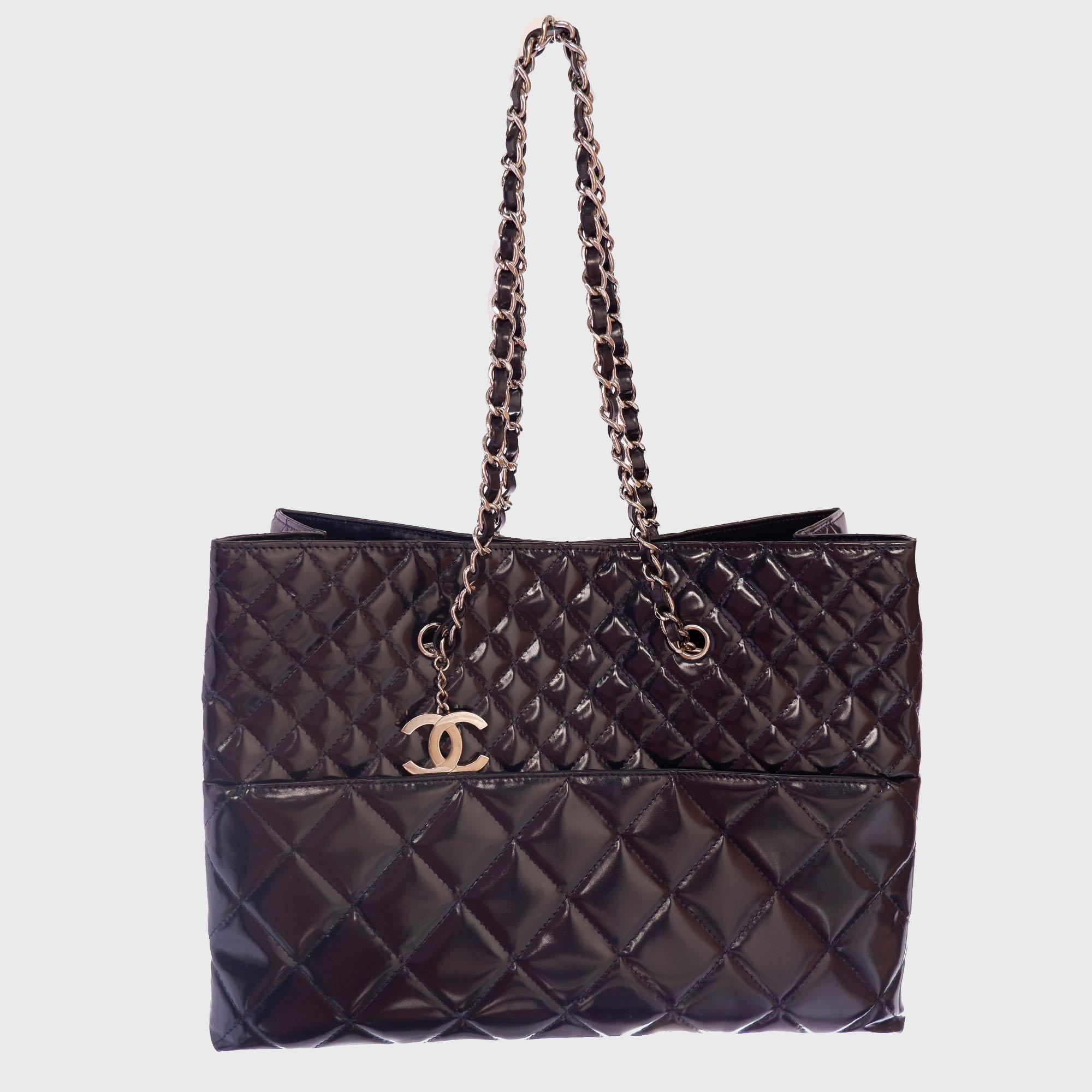 Crafted from black quilted patent leather, this timeless Chanel In The Business tote bag features dual woven-in leather chain straps, diamond quilted design, interlocking CC logo charm and silver-tone hardware accents. Its magnetic snap closure