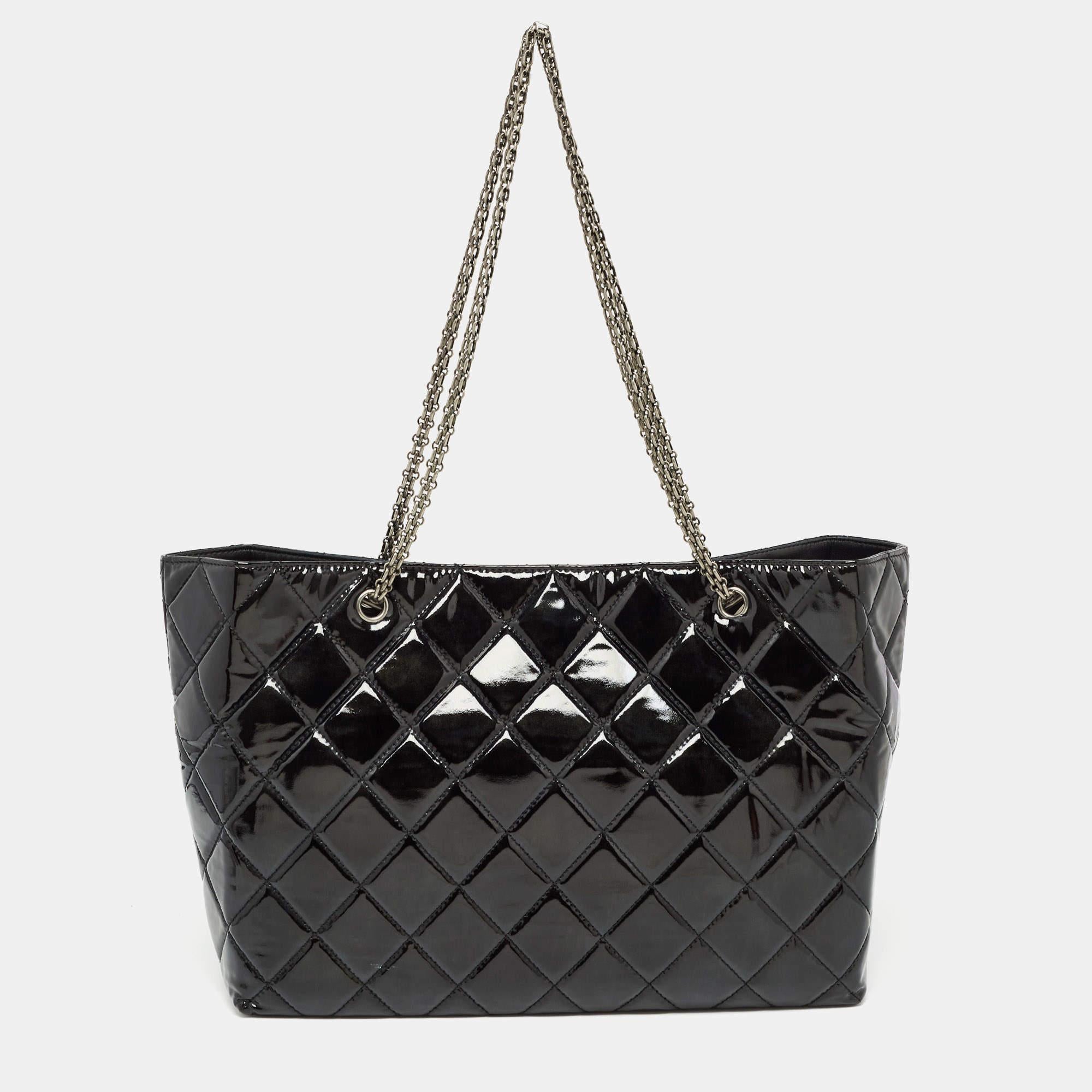 This Reissue East West tote from the House of Chanel is great for everyday use. It has a patent leather exterior with dual chain handles and signature elements. It is provided with a spacious interior for all-day ease.

Includes: Original Dustbag


