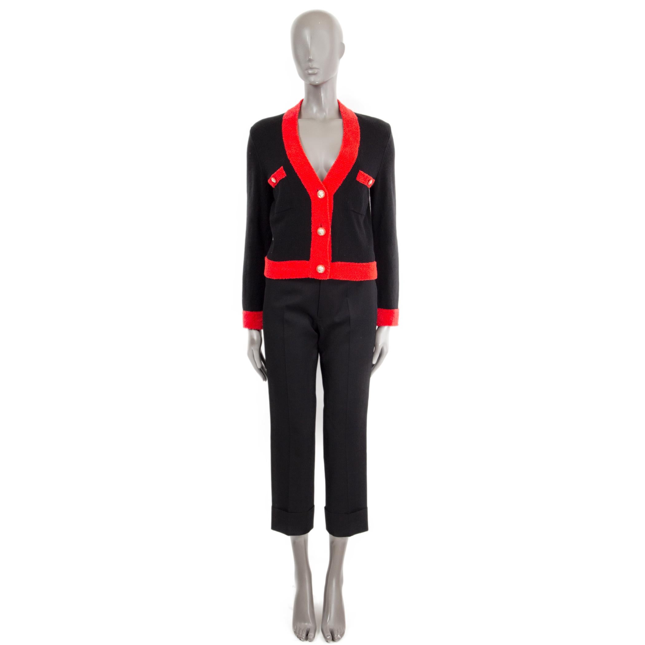 100% authentic Chanel boxy knit jacket in black cashmere (73%), wool (19%) and polyamide (8%) featuring a red chenille trim and two chest-pockets embellished with light gold-tone lion head metal buttons. Has been worn and is in excellent condition.