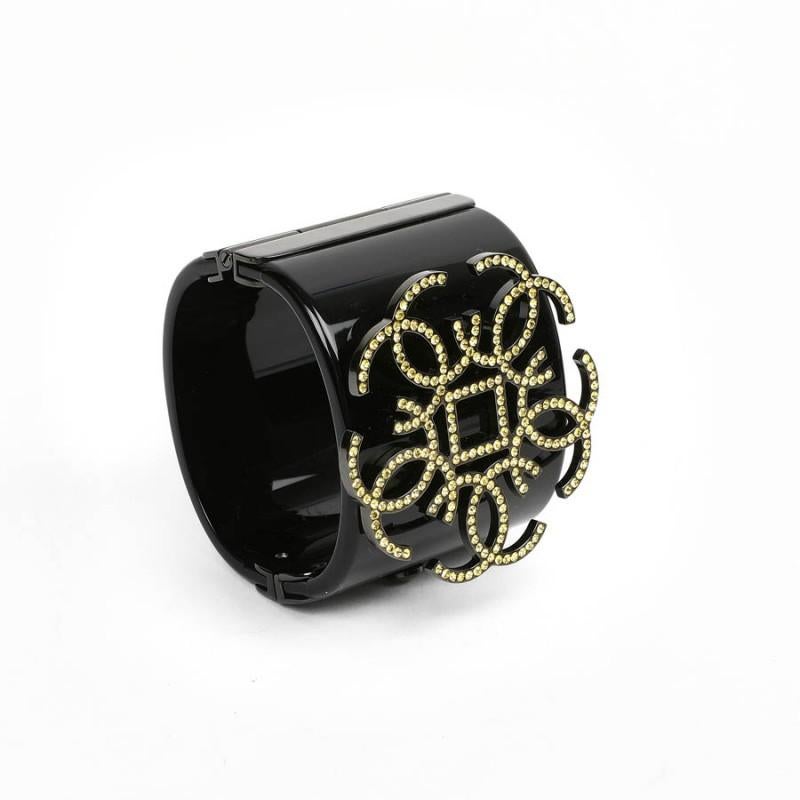 Amazing Black Chanel resin cuff.  The small yellow rhinestones features the iconic CC logo. With a black clasp, the cuff is in good condition, just few marks. The Chanel stamp indicates it's been made in France in  2017. 
This item will be delivered
