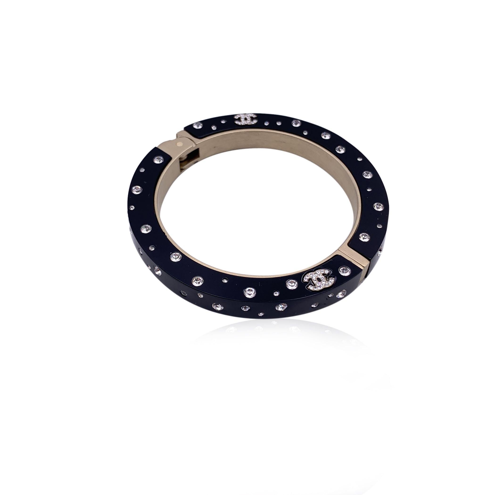 Lovely large cuff bracelet by CHANEL. Black resin with crystal CC logo at center. Hinge opening . Stamped 'Chanel 09 CC P Made in Italy' internally. Will fit up to approx. 6.5 inches - 16.5 cm wrist. . Condition A - EXCELLENT Gently used. Please,