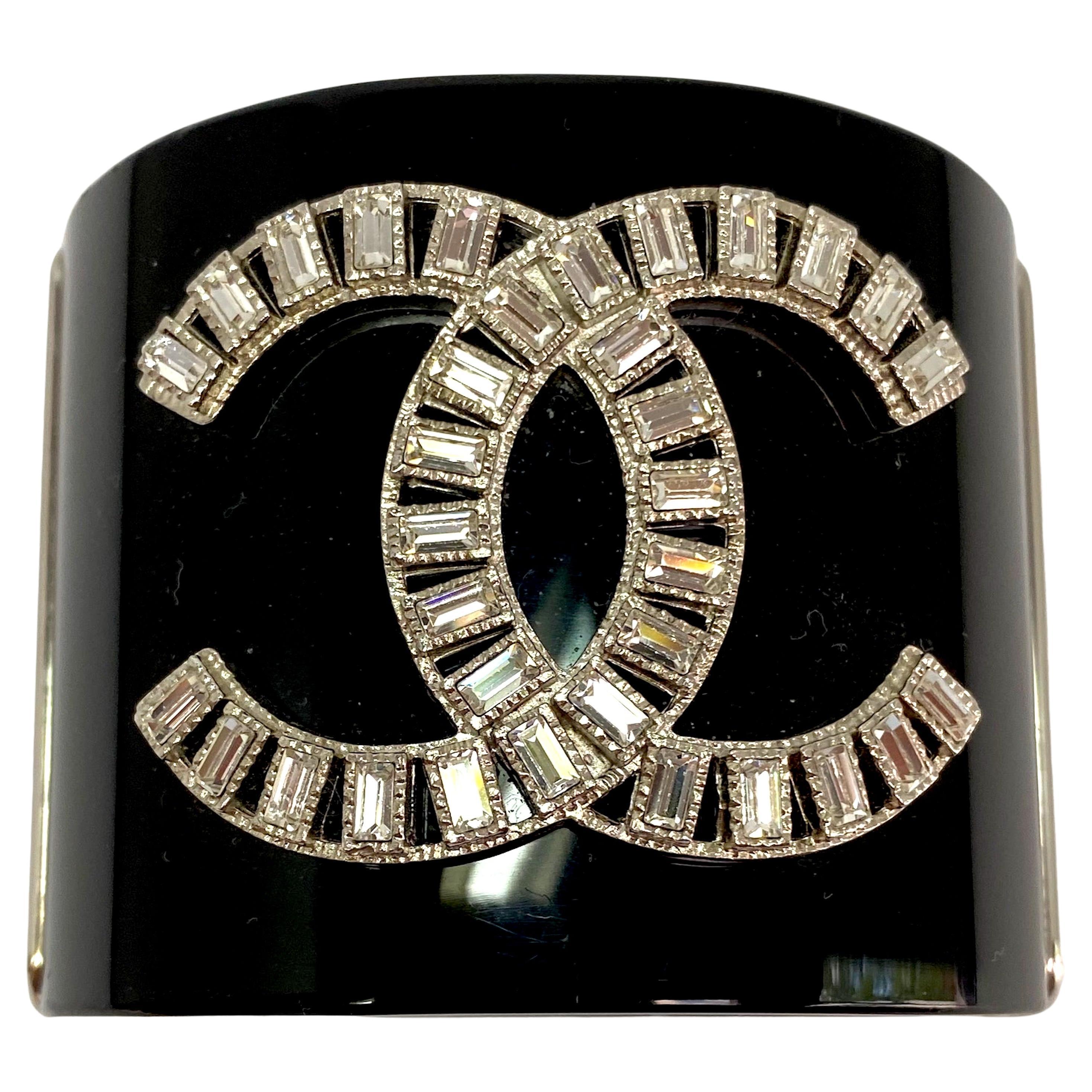 An elegant Chanel black resin / lucite cuff from the Spring 2009 collection. It measures 2 inches wide and has and an interior circumference of 6.75 inches. The top and bottom black resin pieces are securely and nicely mounted in palladium hinged