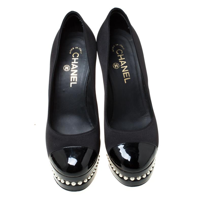 These pumps from Chanel are love at first sight! These beauties are crafted from black satin and flaunt patent leather cap toes. The pair is also equipped with 13.5 cm high heels and solid platforms both which are detailed with glistening pearls.