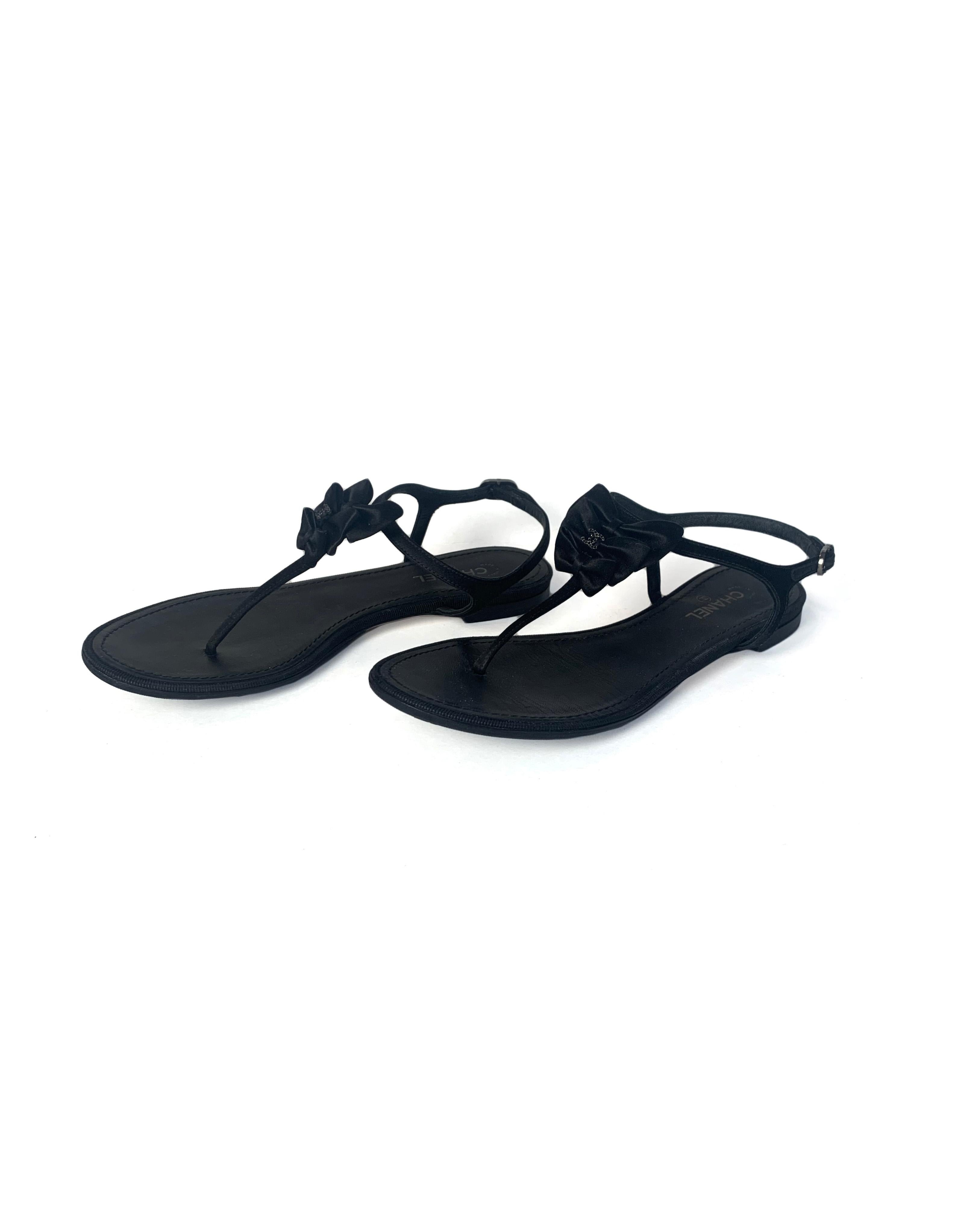 Chanel Black Satin Bow Thong Sandals.  Features three bows with black crystal CC, and crystal encrusted buckle.

Made In: Italy
Year of Production: 2013
Color: Black
Hardware: Gunmetal
Materials: Satin, crystal, grosgrain
Closure/Opening: Adjustable