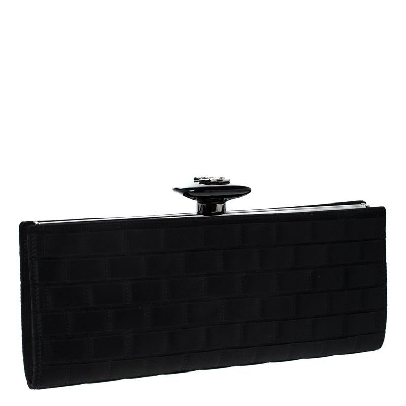 Complete an elite look with this Chanel frame clutch that is perfect for any party or formal event. It features a stunning black color on the satin exterior with a silver-tone metal opening with a push-lock closure and a well sized