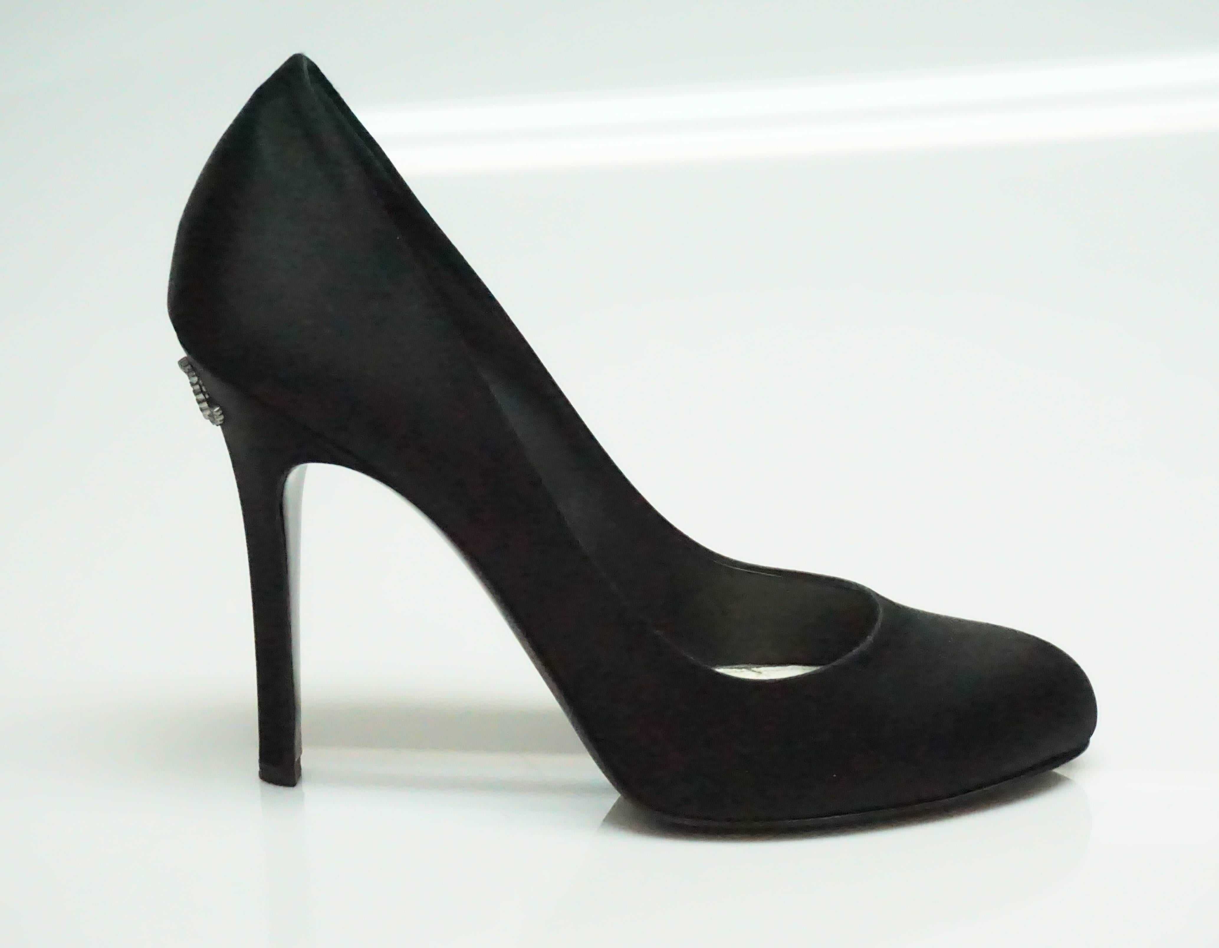 Chanel Black Satin Classic Pump w/ CC logo - 40.5  These beautiful pumps are in excellent condition. They have barely and wear to them.There is some discoloring on the soul of the shoe and there is some wear on the very bottom. 
Heel height: 4.5