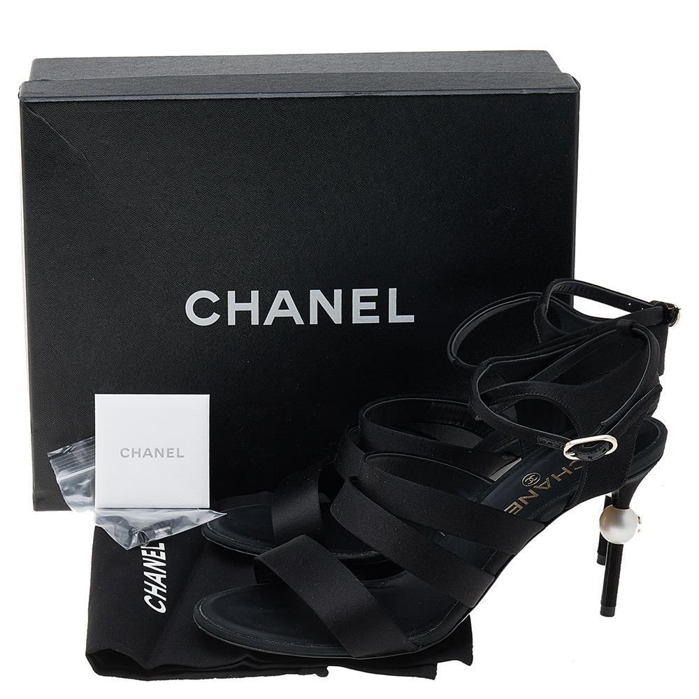 These sandals from the House of Chanel are simply delightful! Made from black satin, these sandals are embellished with pearl-detailed heels and an ankle strap feature. They are beautified with gold-toned hardware and 9 cm heels. Add a chic touch to