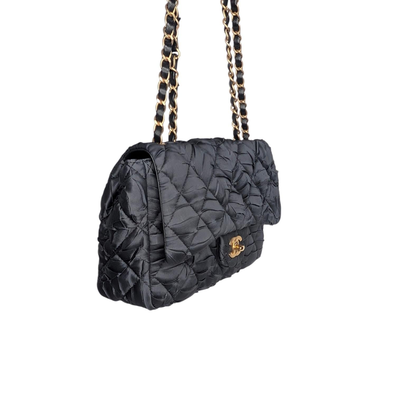 Chanel Satin Quilted Pleated Medium Single Flap in Black. This chic shoulder bag is crafted of fine washed satin, quilted and pleated. The bag features an aged gold and leather threaded chain link shoulder straps and a facing flap with a Chanel CC