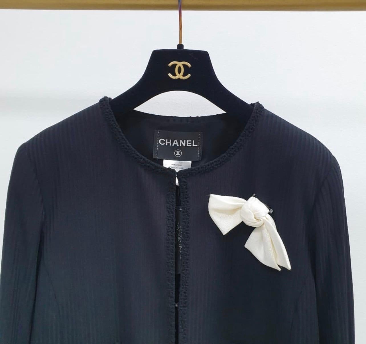 A Chanel Black Self Stripe Bow Trim Jacket. 
This Self Stripe Bow Trim Jacket from Chanel is just the thing for those days you want to achieve something that is charismatically corporate. 
It features smooth, striped construction with a fitted