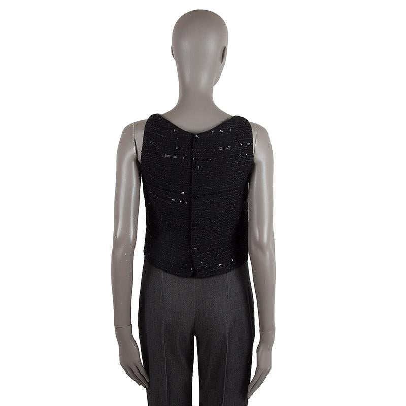 Chanel high v-neck tank-top in black tweed fabric and sequins (missing tag). Closes with black plastic buttons on the back. Lined in black silk blend. Has been worn and is in excellent condition. 

Tag Size Missing Size
Size M
Shoulder Width 29cm