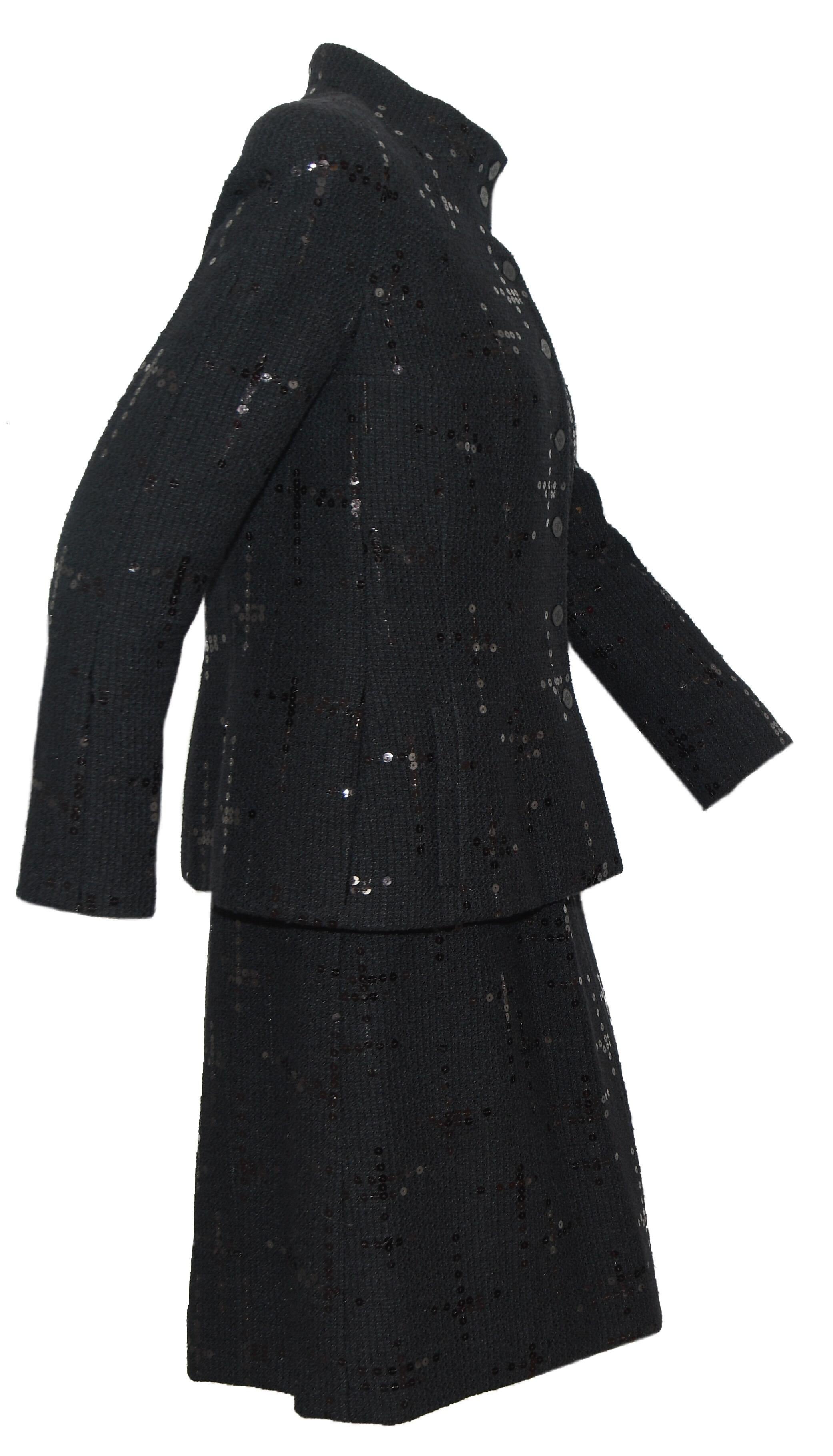 Chanel black tweed skirt suit decorated with scattered black sequins throughout.  The jacket has an up collar with 2 CC buttons and 5 same buttons at front for closure.   Jacket contains two side slit pockets and is lined in Chanel CC logo black