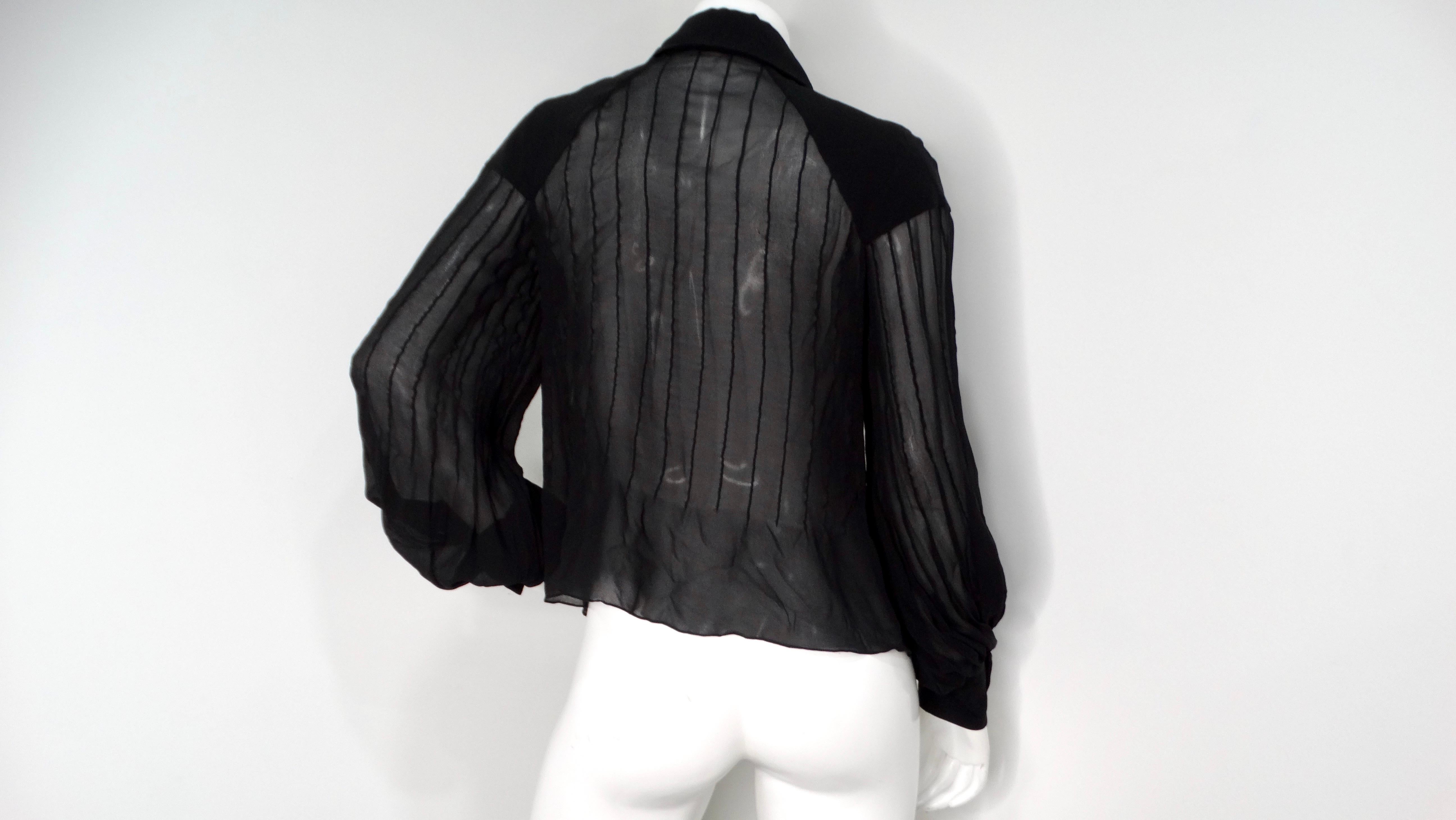 Elevate your wardrobe with the Chanel Black Sheer Silk Button-Up Long-Sleeve Blouse, a sophisticated piece that embodies classic elegance and modern style. Crafted from luxurious sheer silk, this blouse features a tailored fit complemented by