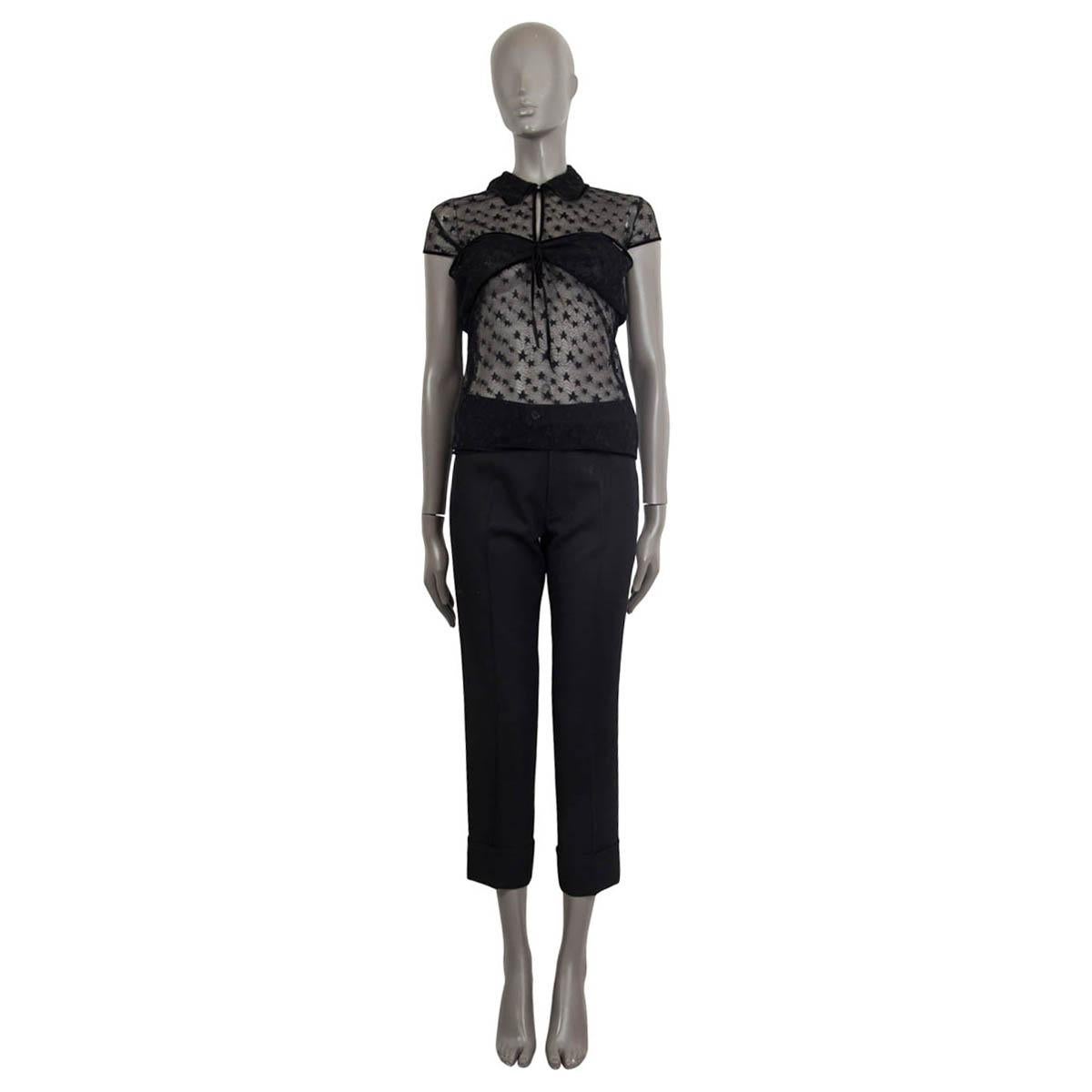 100% authentic Chanel cap sleeve top in black sheer star lace (nylon-spandex blend - please note the content tag is missing). Embellished with embroidered stars all over the top and a black satin band on the collar, sleeves and the hemline. Has an