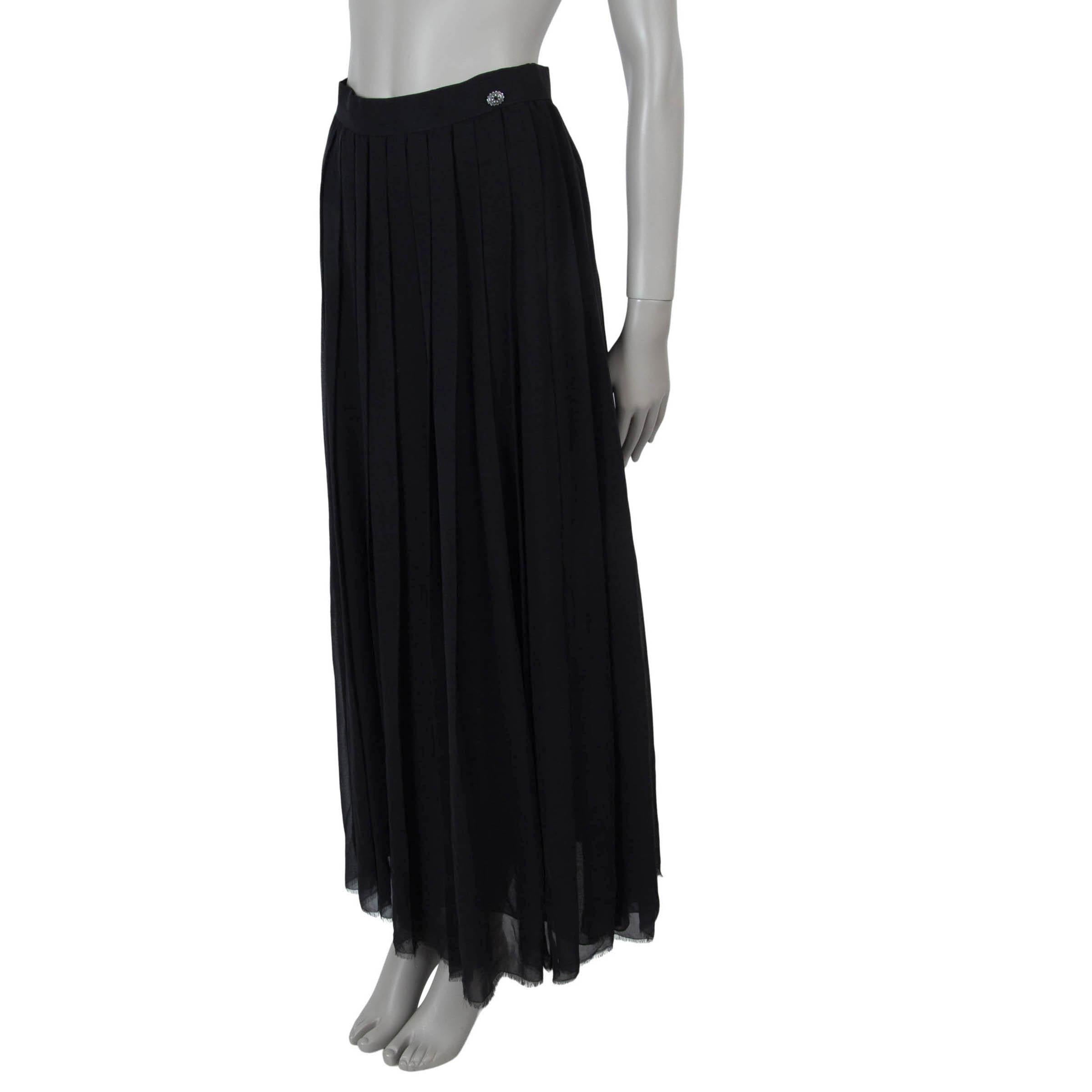 This 100% authentic Chanel pleated skirt in black chiffon silk (100%) exudes timeless elegance. It features a flowy, A-line silhouette with a maxi length and a crystal-embellished button at the waist for a touch of sophistication. The skirt opens